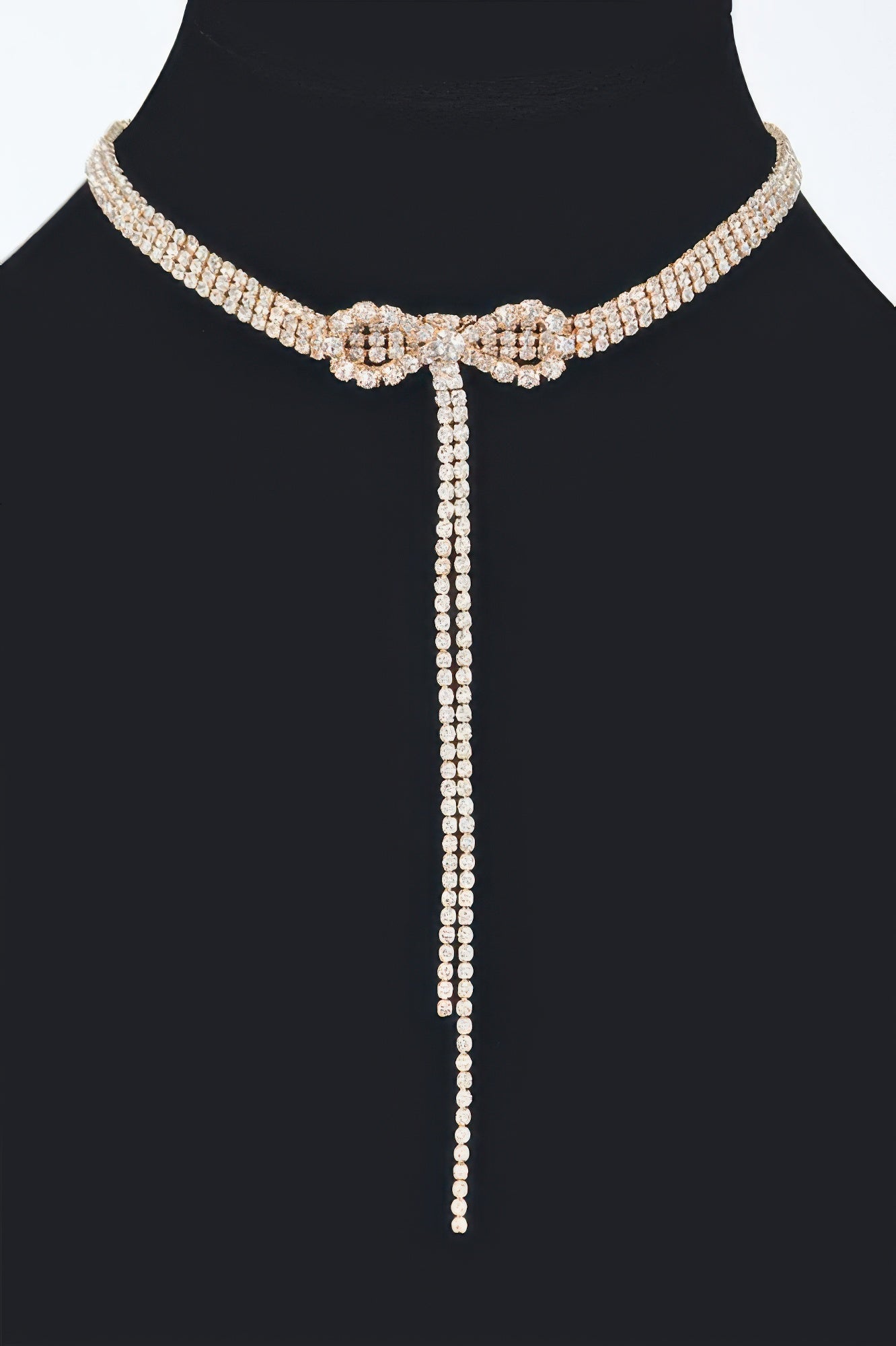 Rhinestone bow string choker with long dangling tail, gold-tone