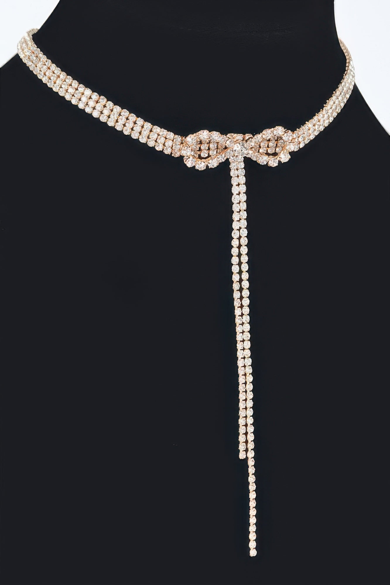 Gold-tone rhinestone choker with bow center and long vertical drop