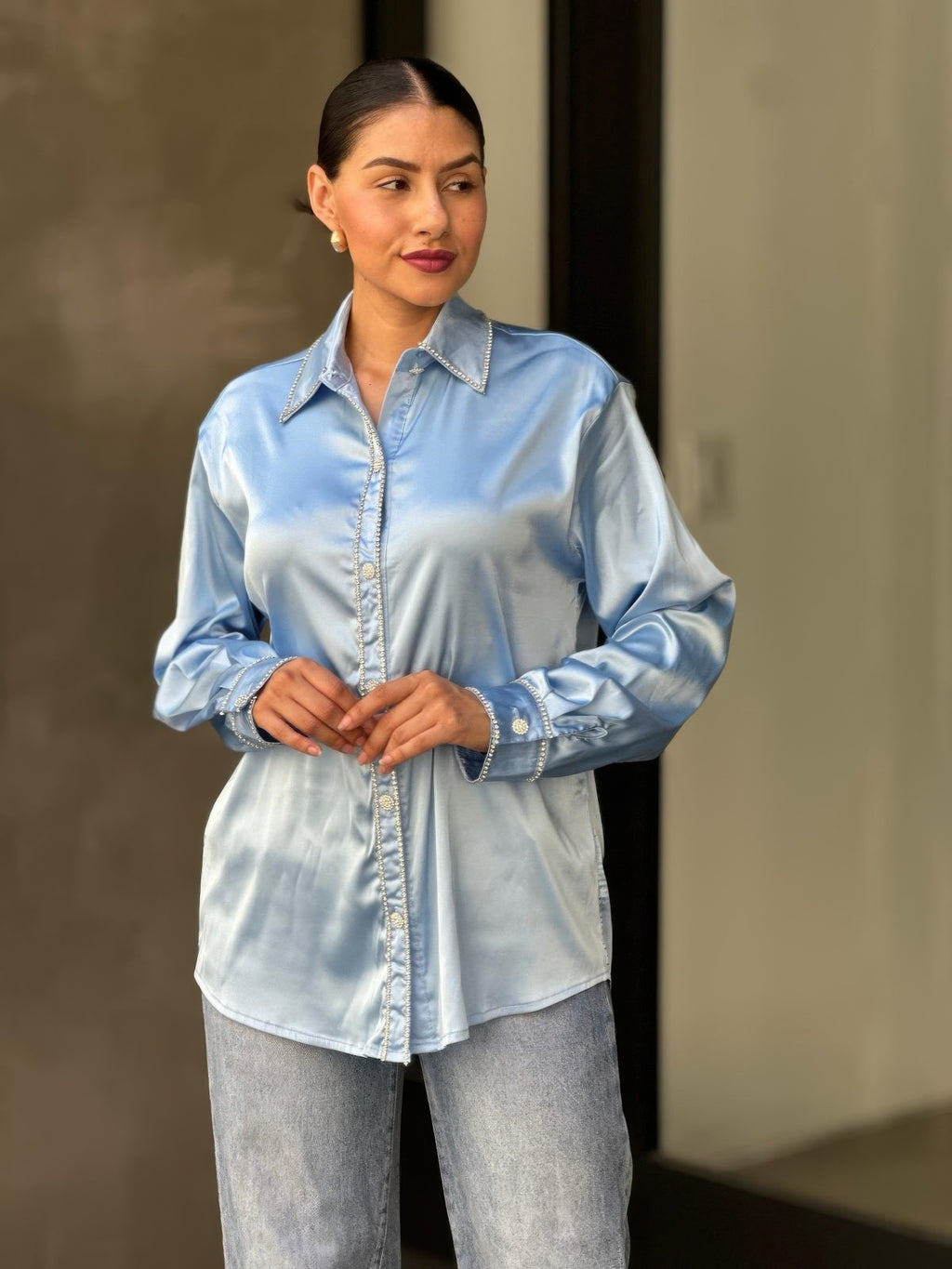 Light blue satin button-down blouse with rhinestone buttons and long sleeves