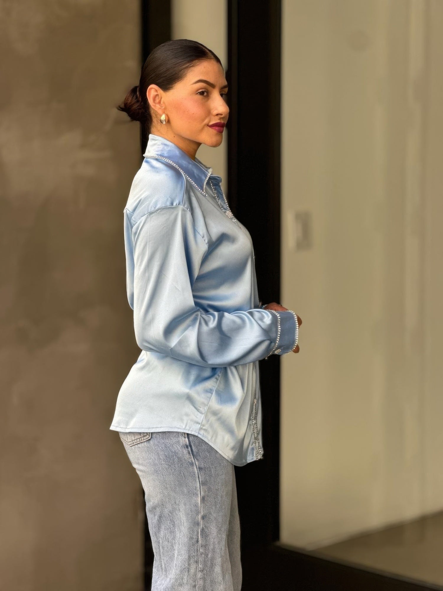 Light blue satin button-down blouse side profile with rhinestone-lined front