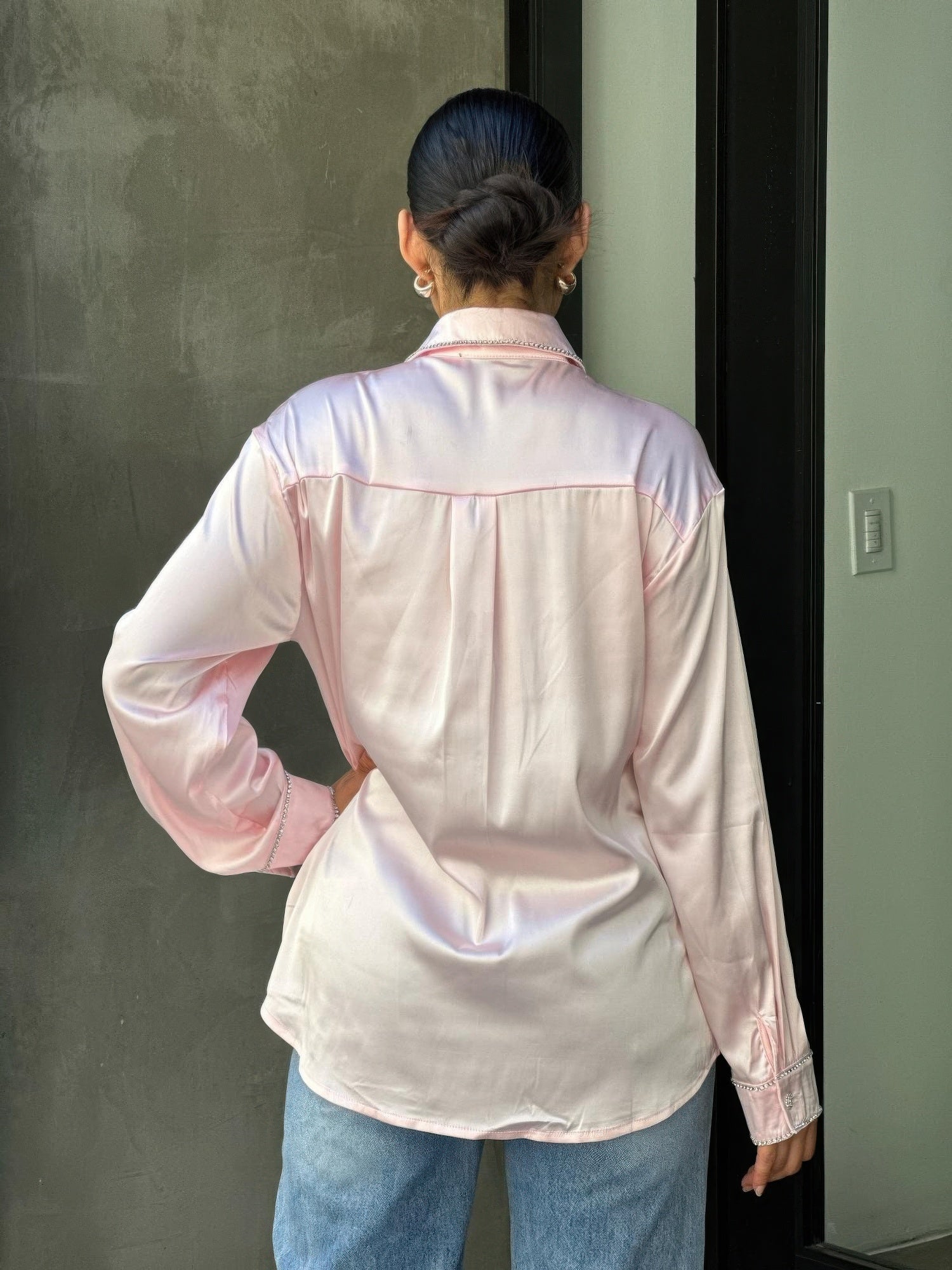 Back view of pale pink satin button-down blouse with rhinestone-trimmed collar seam