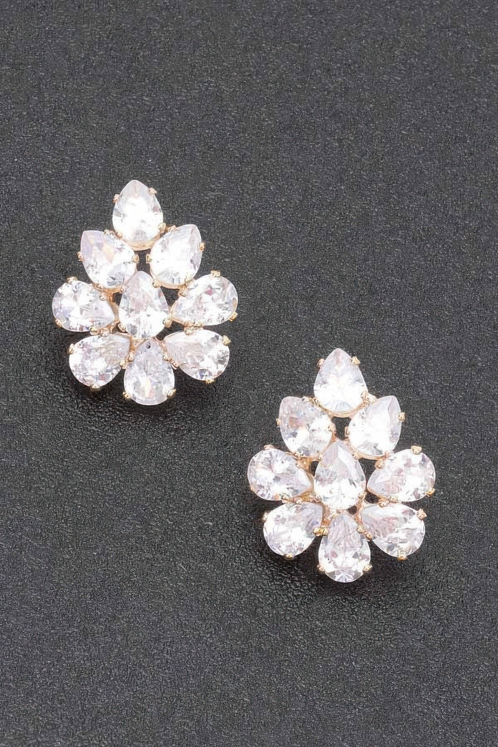 Pendientes flor de pedrería con piedras claras, montura tono dorado