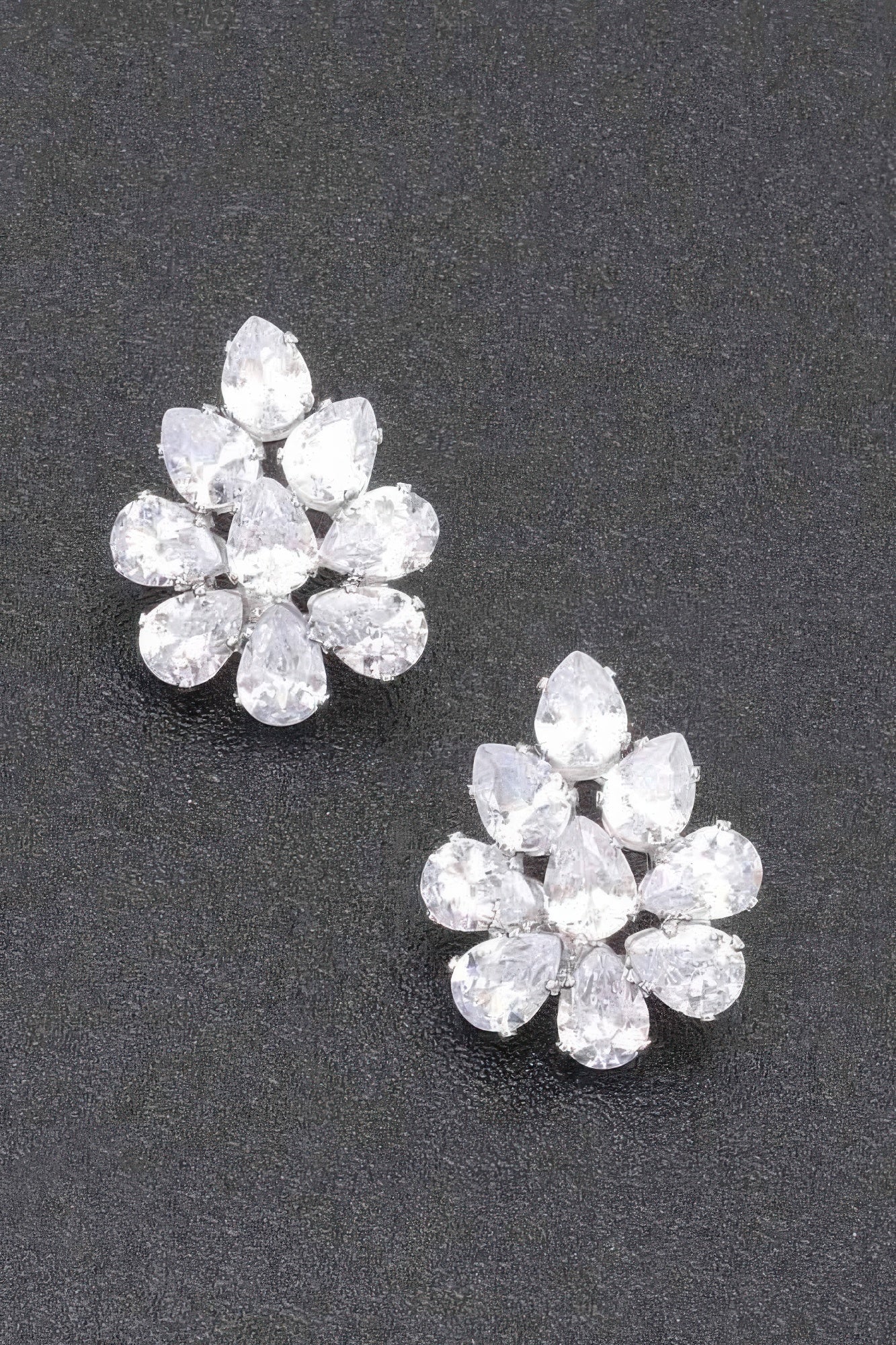 Pendientes flor de pedrería, piedras claras, montura tono plateado