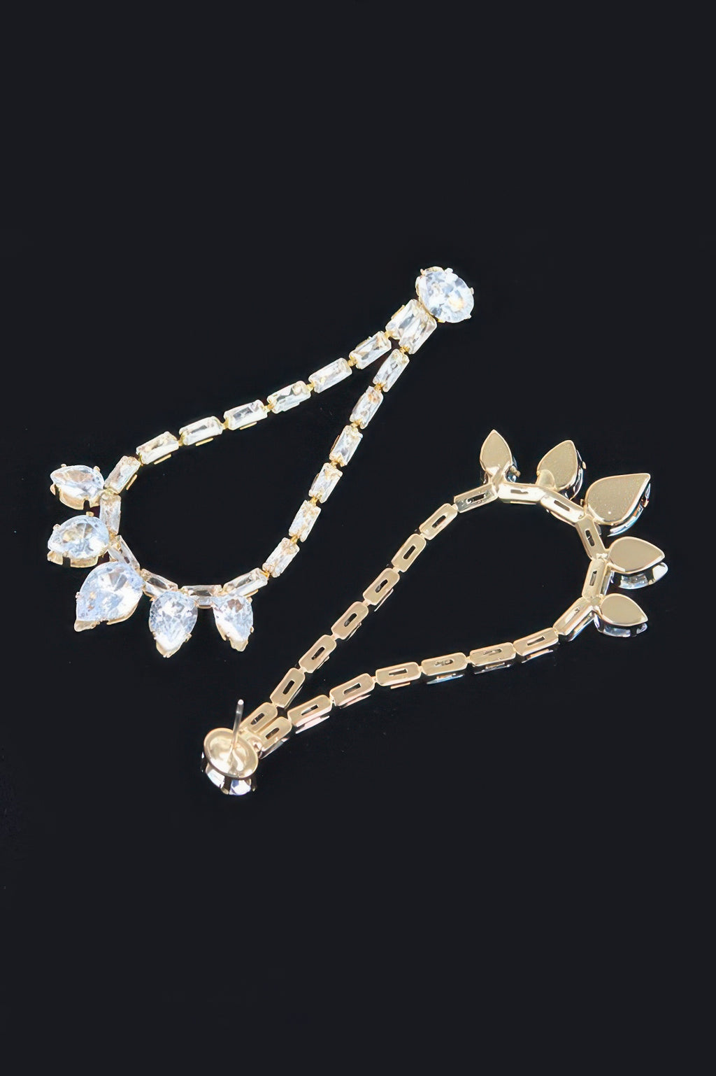 Gold-tone rhinestone drop earrings with linked clear stones and leaf charms
