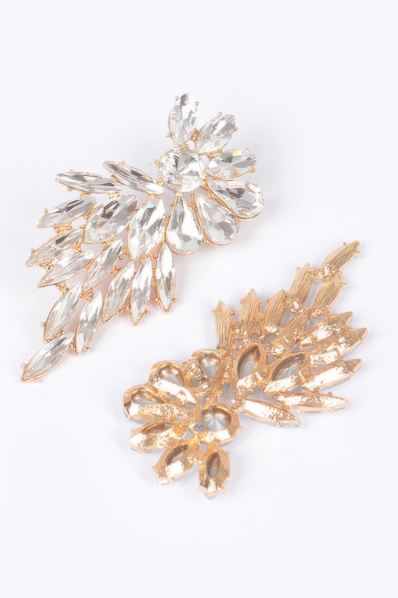 Rhinestone earrings, clear stones with gold-tone starburst petals, side close-up