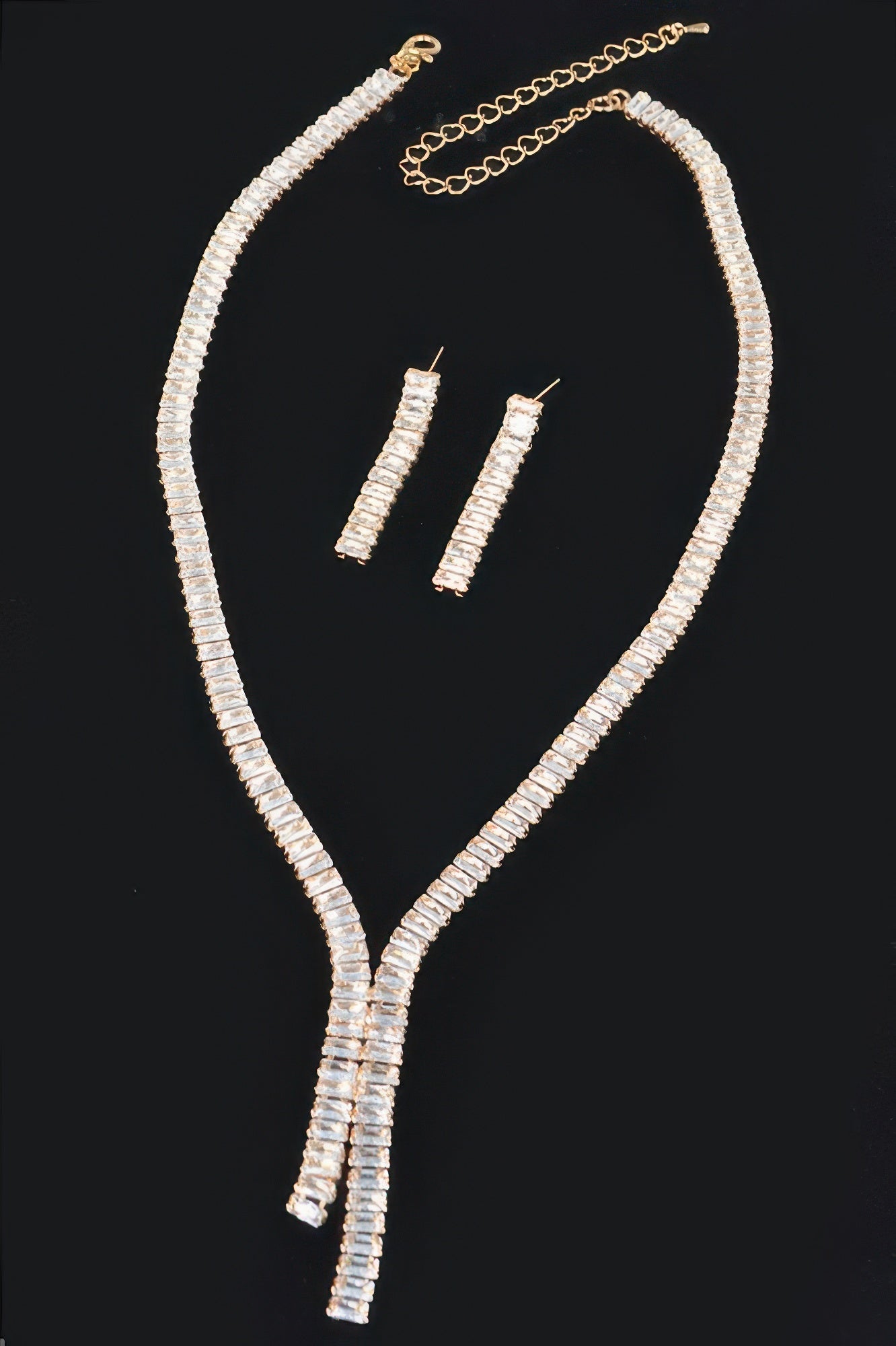 Gold rhinestone necklace with linked chain, Y-drop pendant, and rectangular stud earrings
