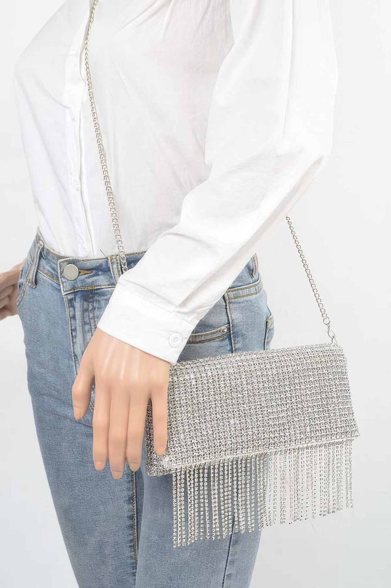 Rhinestone fringe clutch held in hand with textured rhinestone front