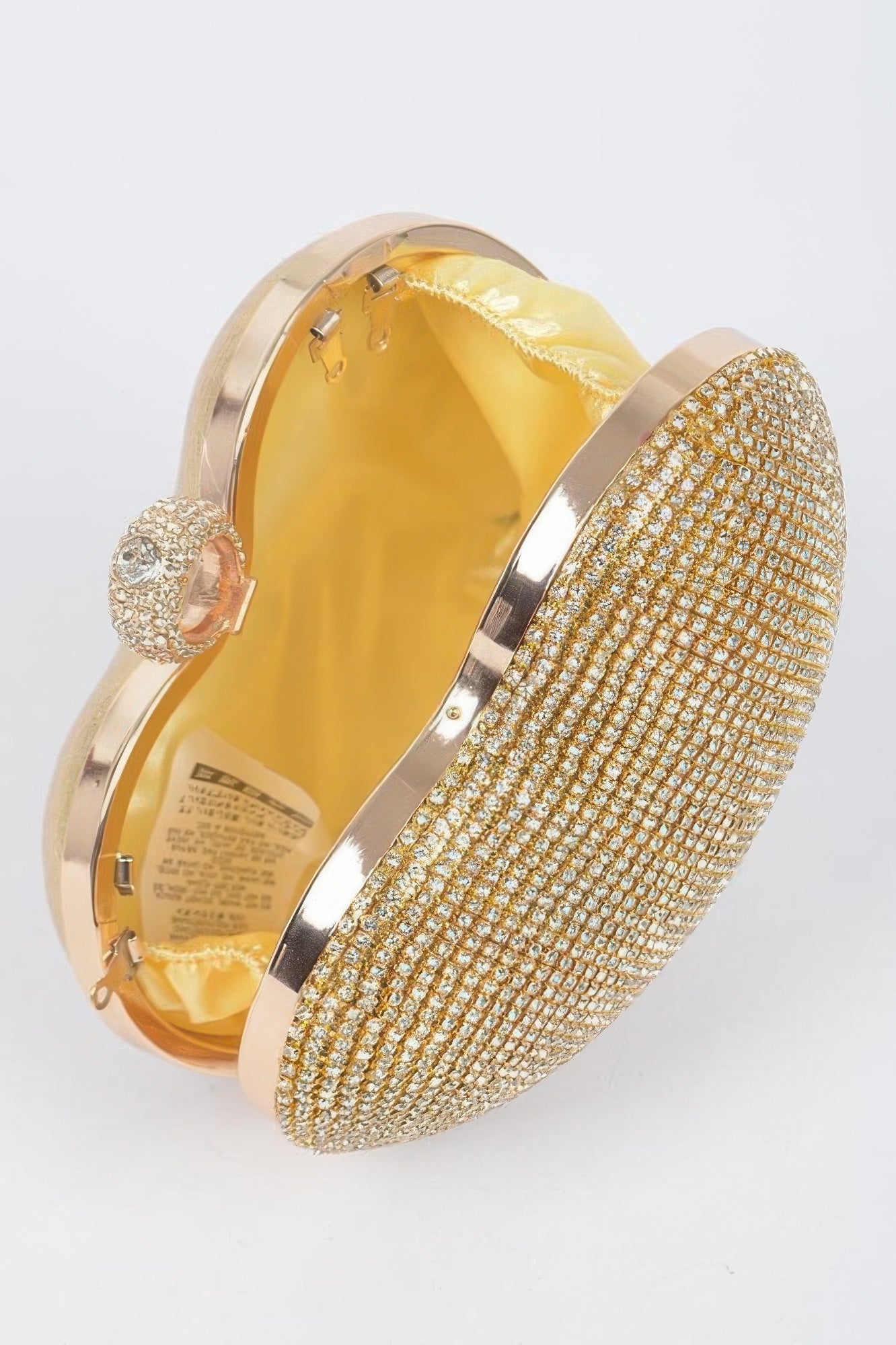 Gold heart clutch with rhinestone body and open frame showing satin interior