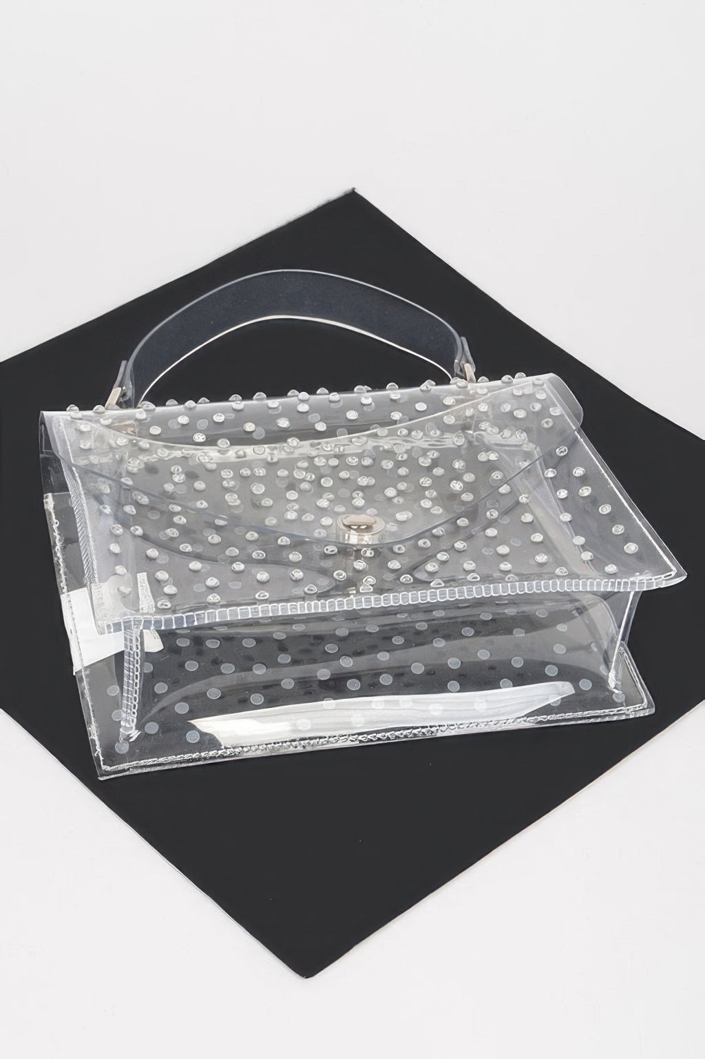 Clear silver rhinestone crossbody bag laid flat, open front flap and layered pockets.