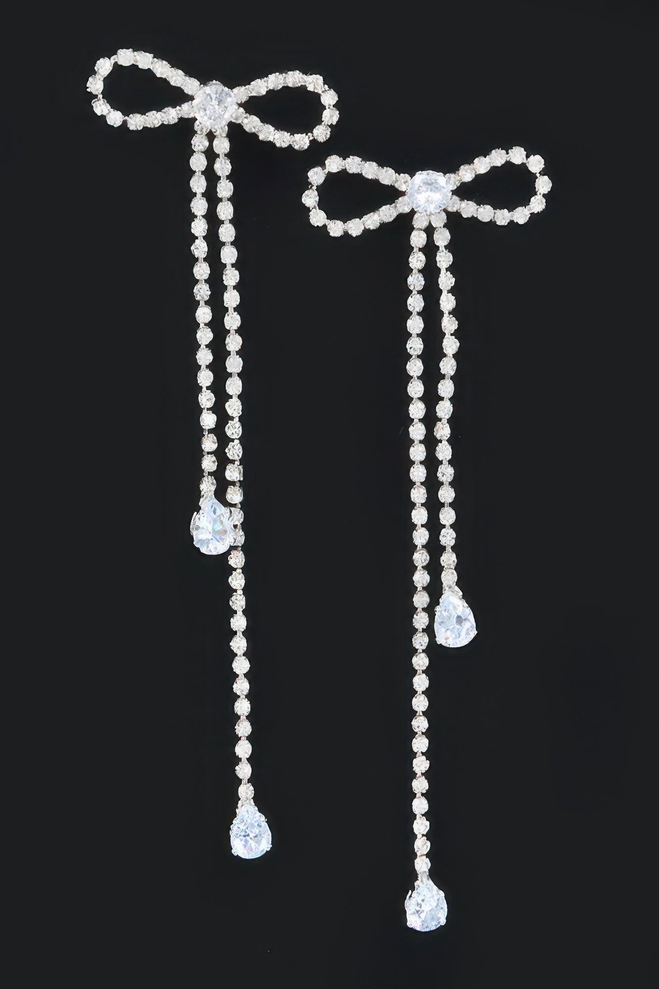 Pair of silvertone rhinestone ribbon earrings with bow ends and teardrop drops