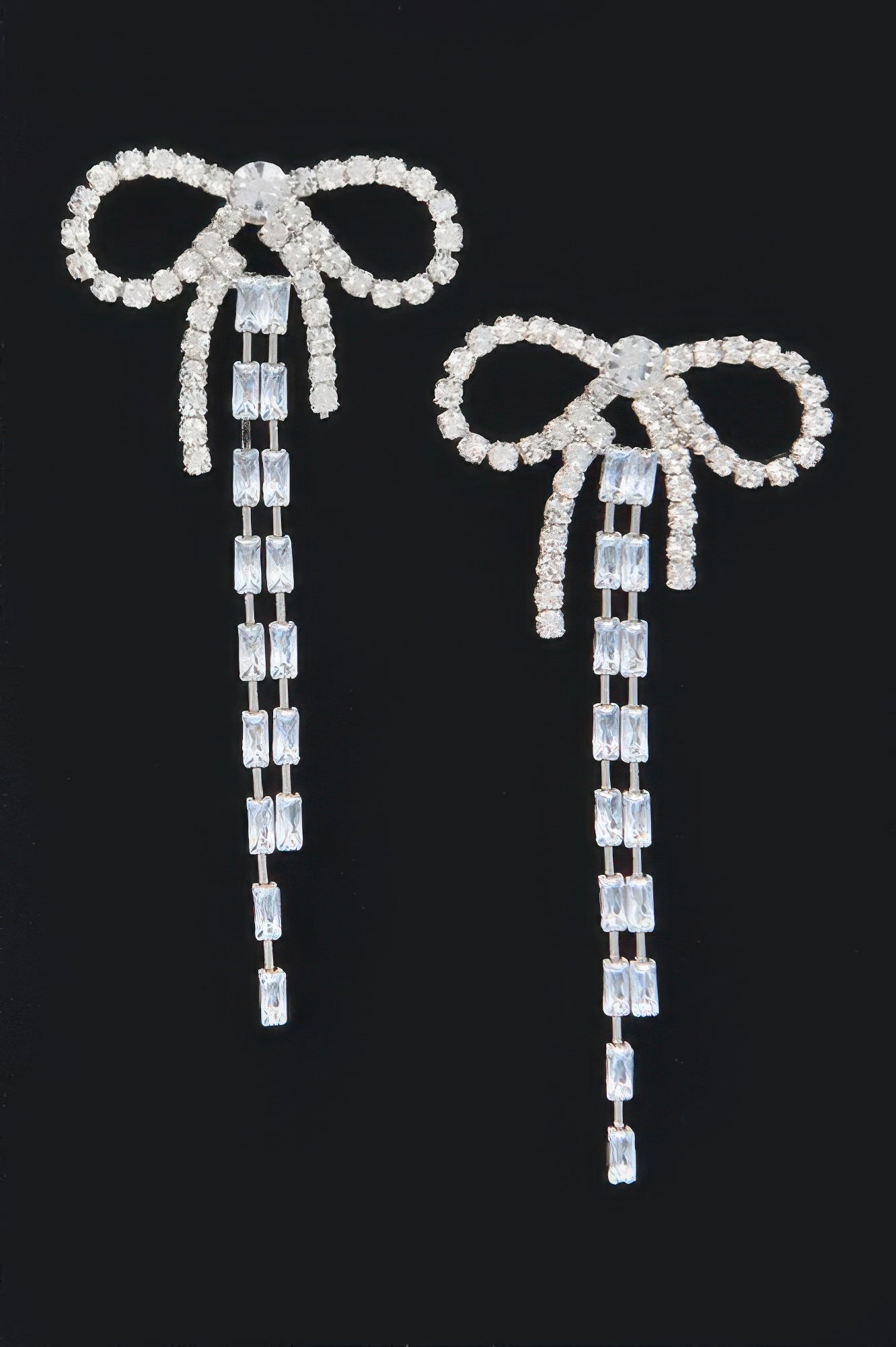 Pair of silver rhinestone ribbon earrings with bow-style loops and vertical crystal tassels