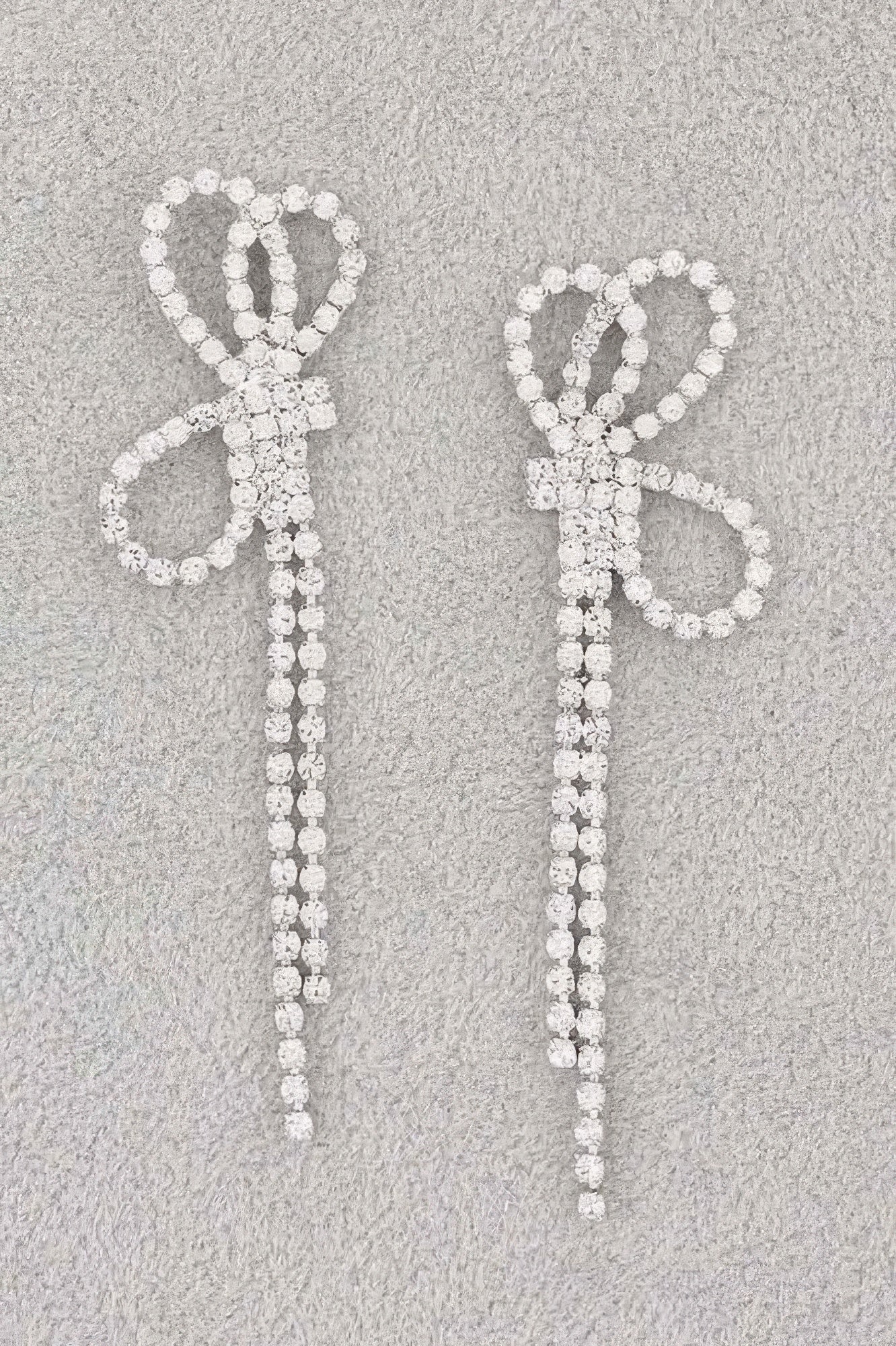 Rhinestone ribbon drop earrings with heart-like bow motif and long sparkly strands