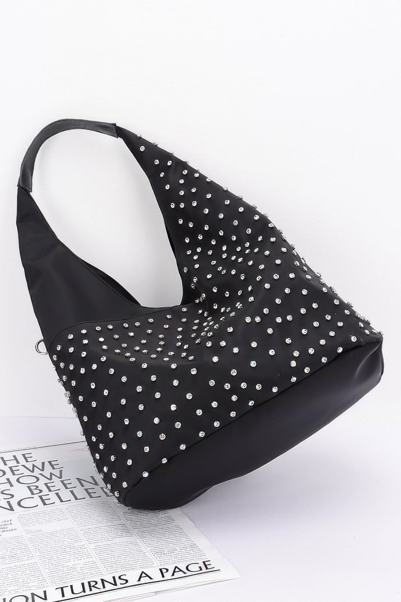 Black rhinestone-studded bindle bag with wide handle and silver studs across the front