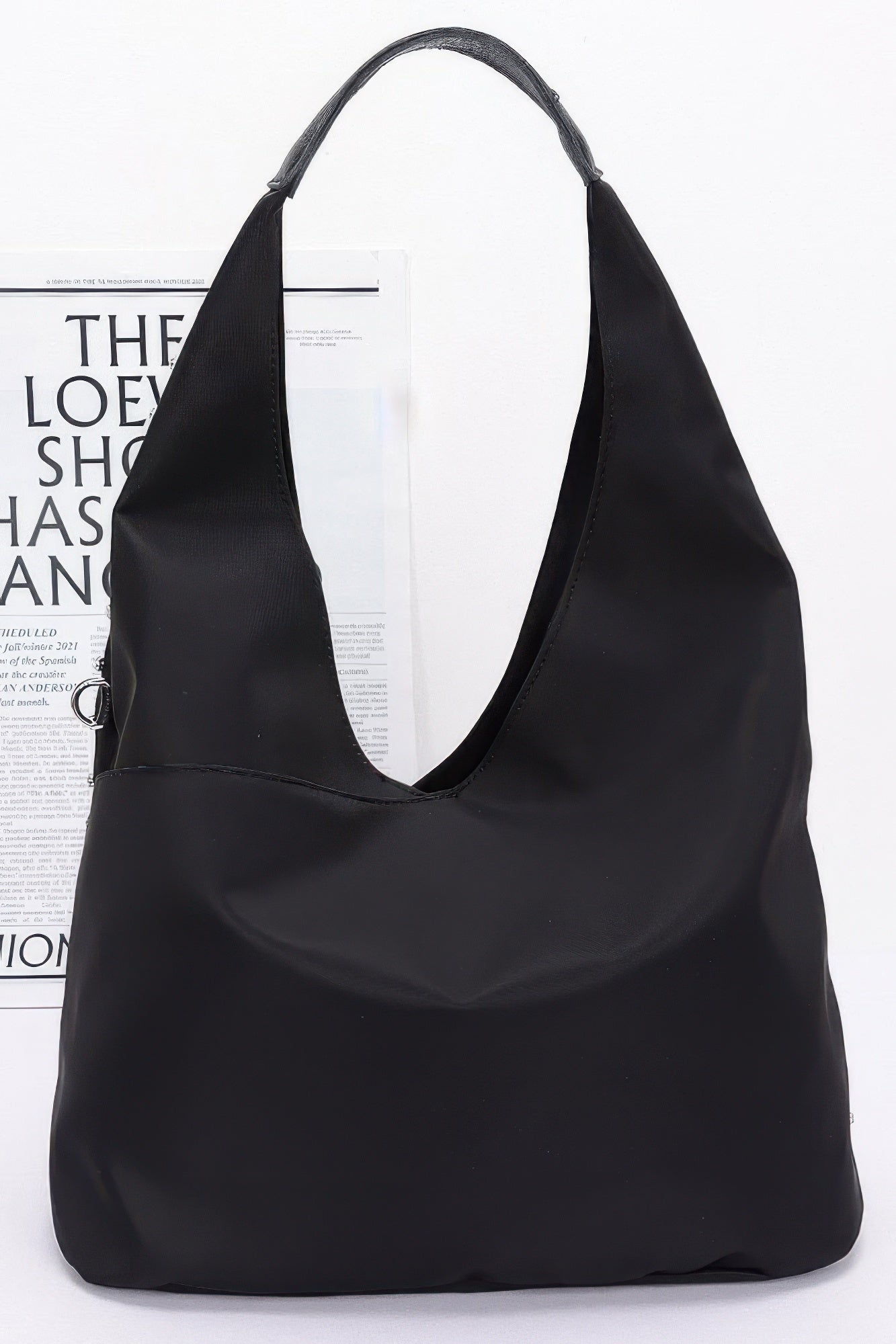 Sleek black hobo-style bag with wide handles, smooth finish, no rhinestone studs visible