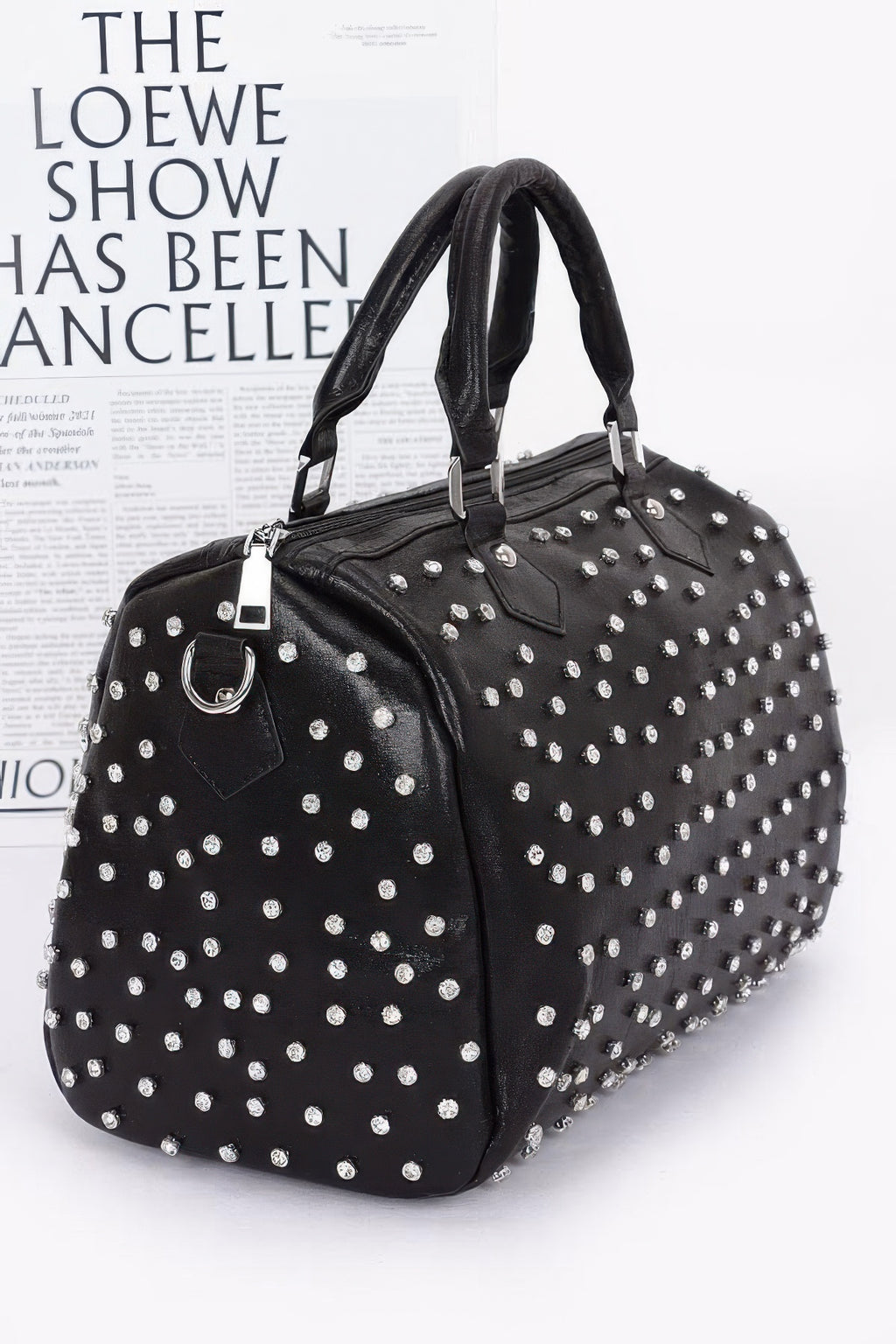 Black rhinestone bowling bag with silver studs, curved top handles, and side strap