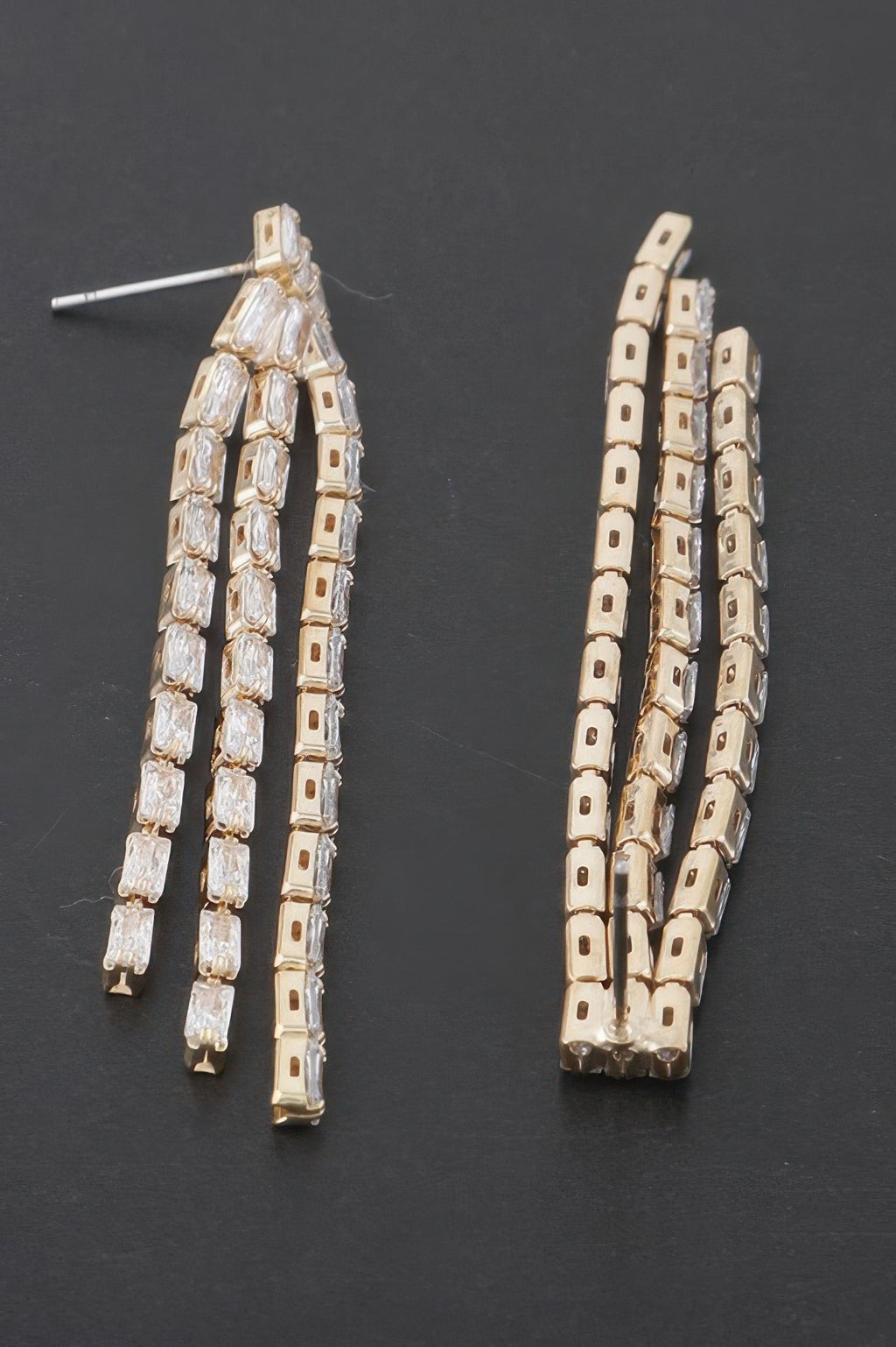 Rhinestone tassel earrings, gold-tone clear stones, angled view