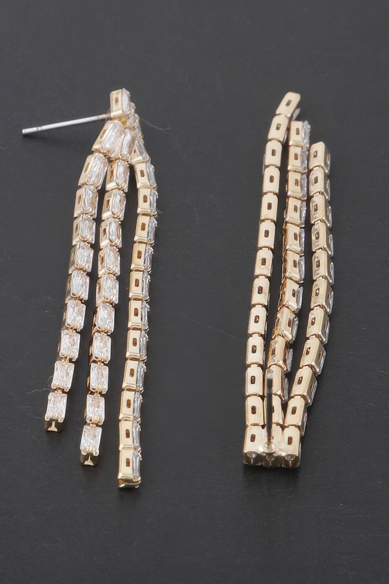 Rhinestone tassel earrings, gold-tone clear stones, angled view
