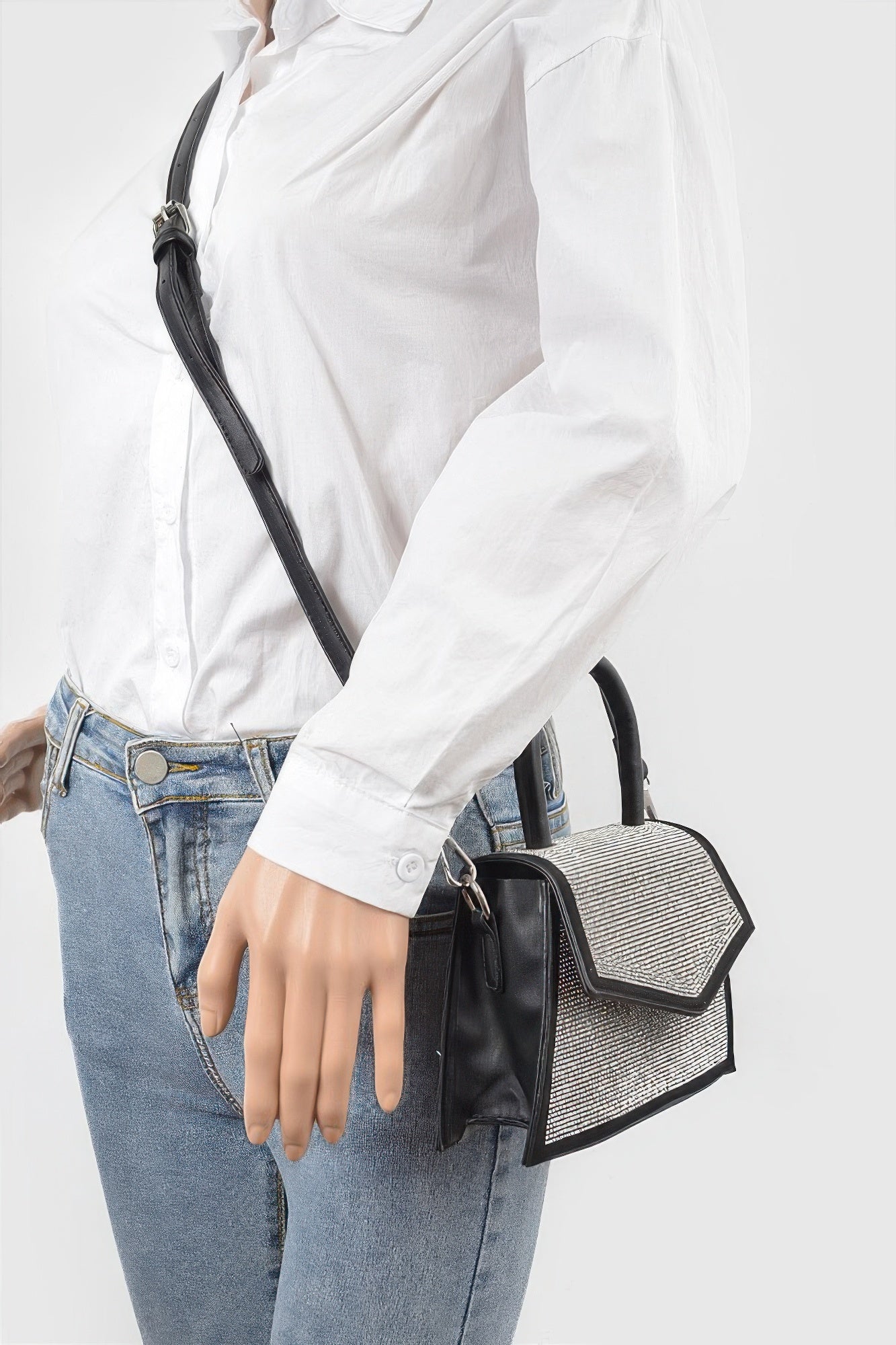 Black crossbody bag with rhinestone flap, short top handle, and adjustable shoulder strap