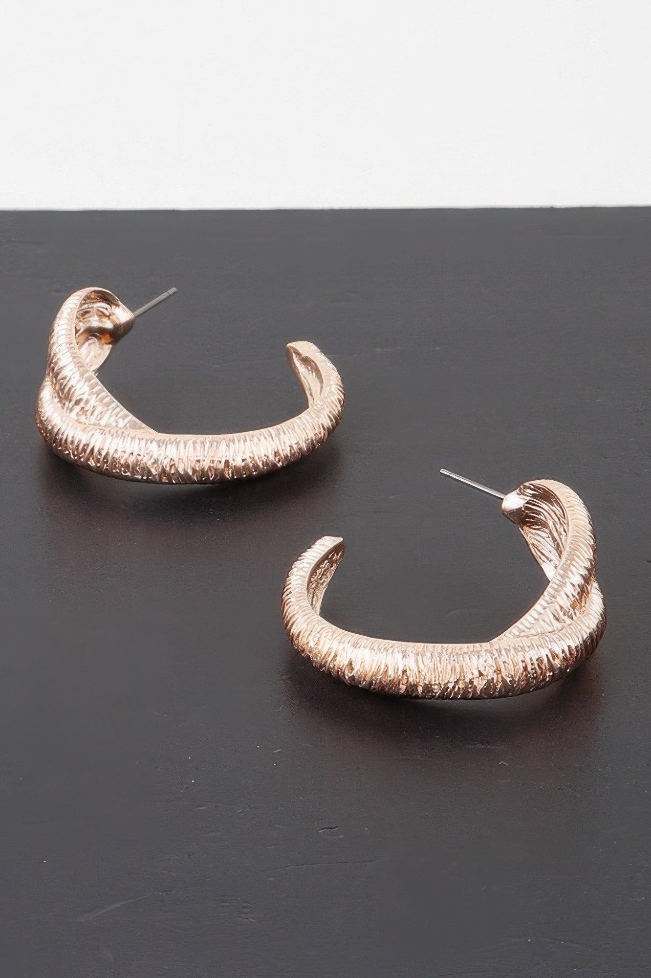 Ribbed intertwined hoop earrings, gold-tone finish with textured curved design