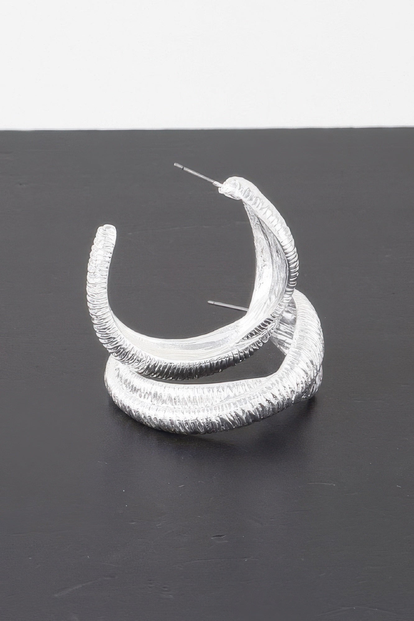 Ribbed intertwined hoop earrings, silver-tone finish with ridged nested loop design