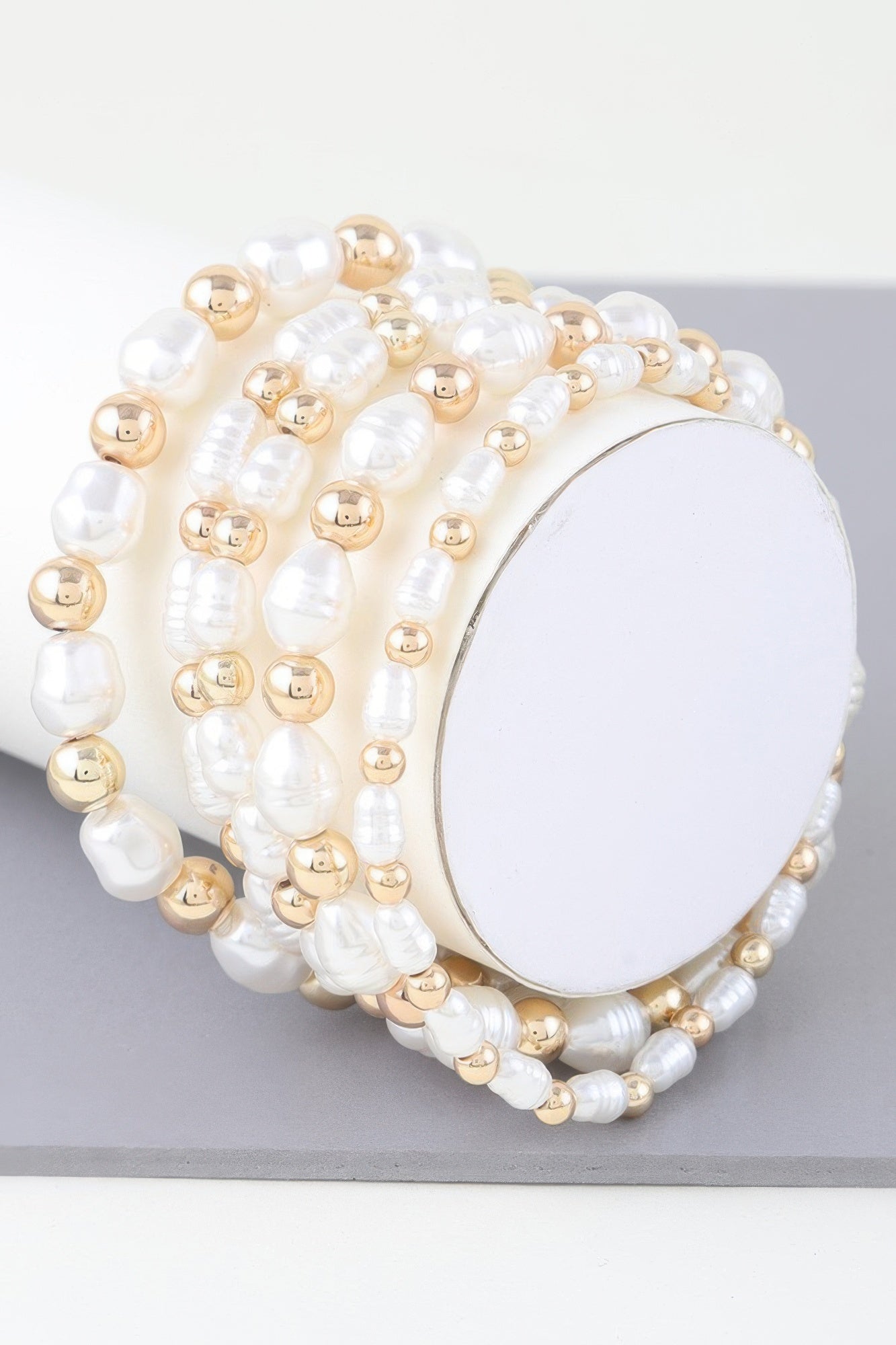 Ribbed pearl beaded bracelet with gold-tone spacers and oval clasp centerpiece