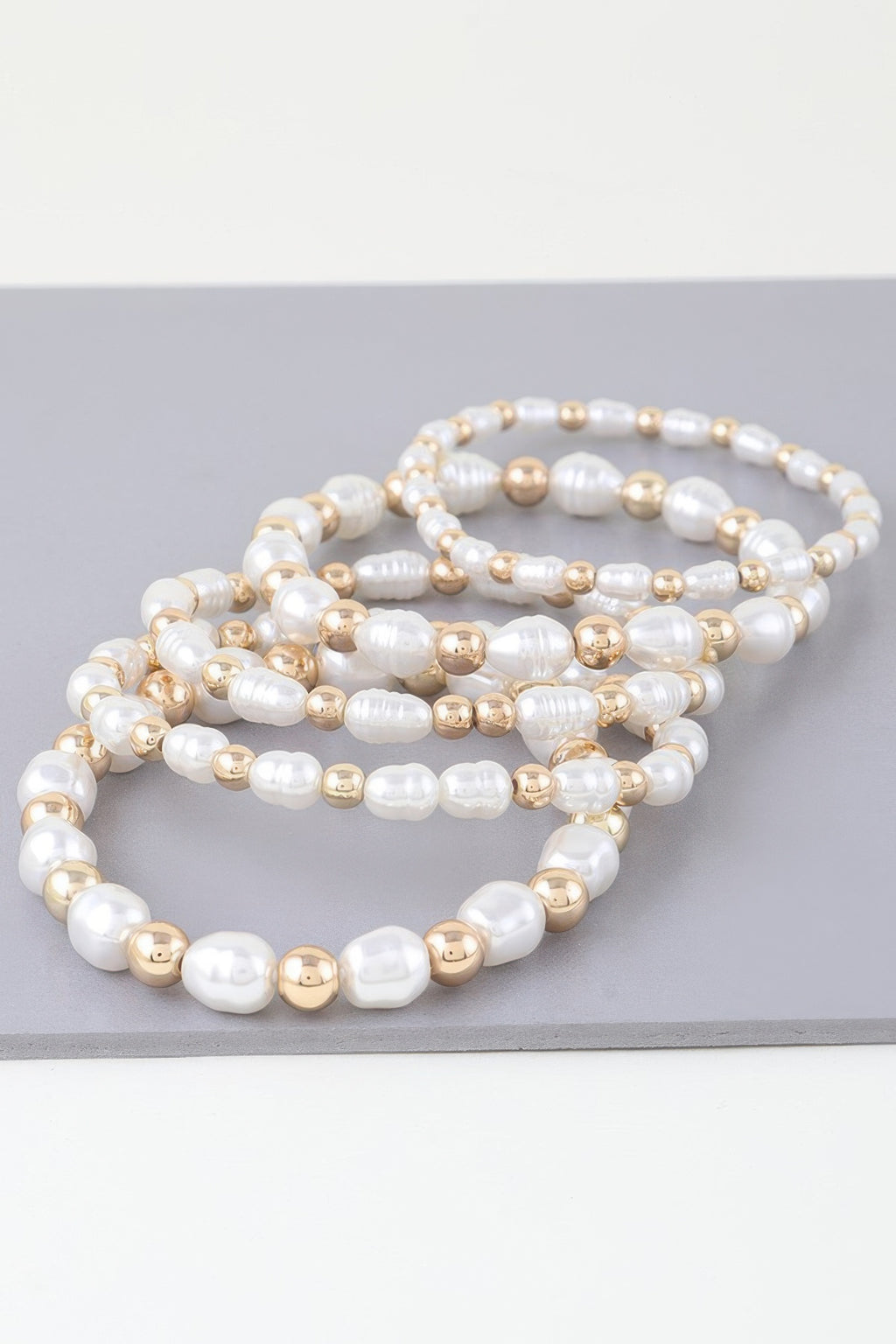 Stacked ribbed pearl and gold-tone bead bracelet, curved profile