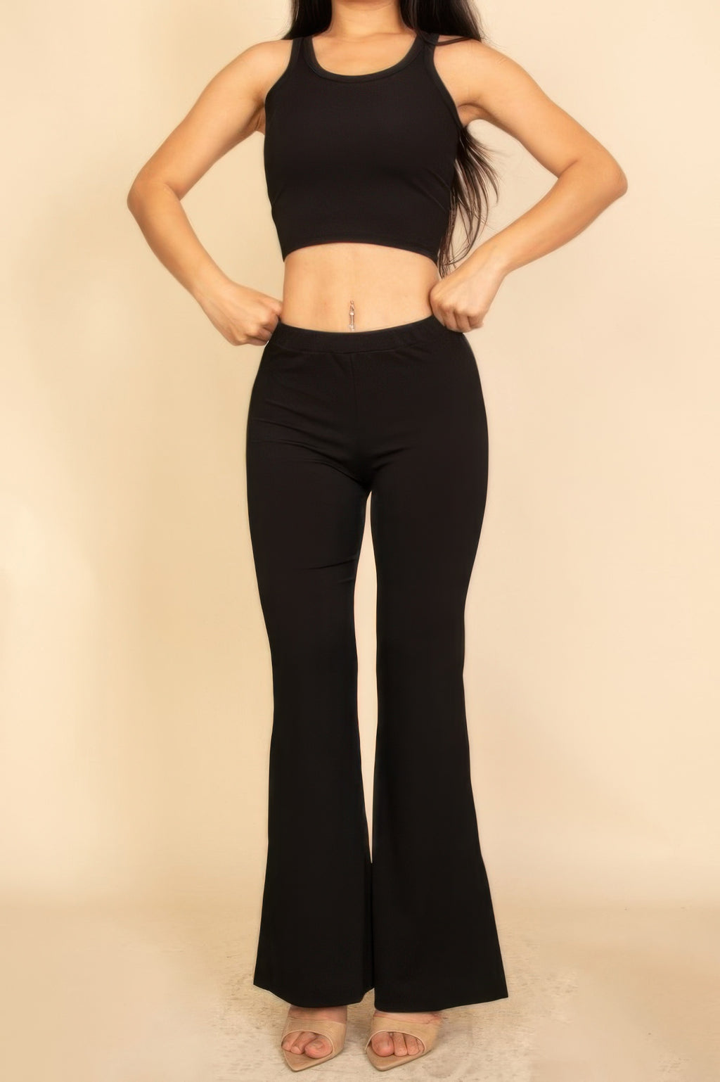 Black sleeveless crop top and flared pants set, front view