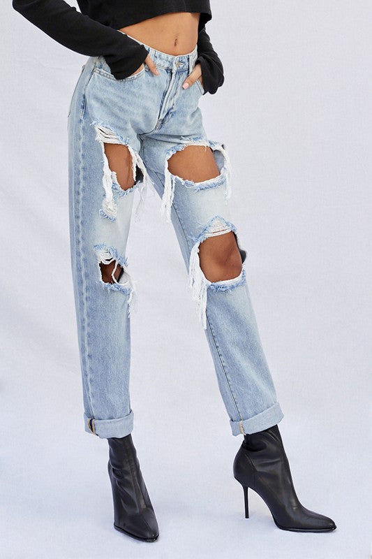 Light ripped baggy jeans with several leg cutouts and frayed inner seam edges