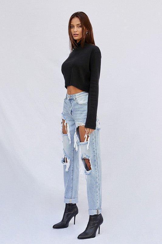 Light baggy jeans profile view with patchwork thigh and knee rips, frayed hem