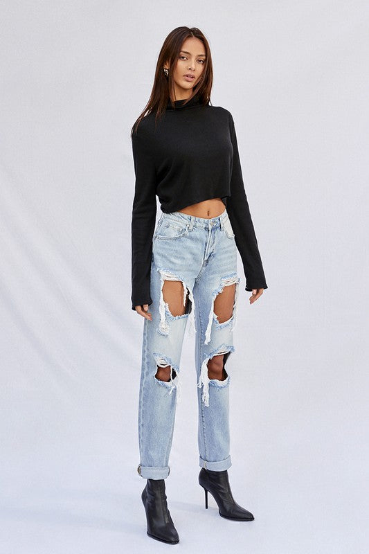 Light baggy jeans front 3/4 view with distressed legs and several torn openings