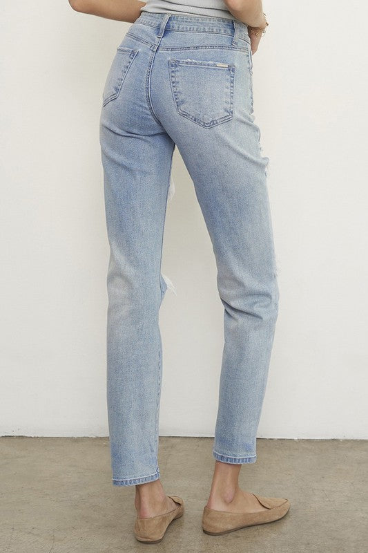 Light wash boyfriend jeans, back view with distressed seat and frayed hem