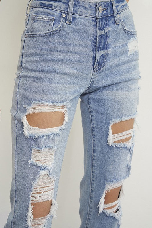 Close-up: light wash ripped boyfriend jeans with torn knee and thigh openings