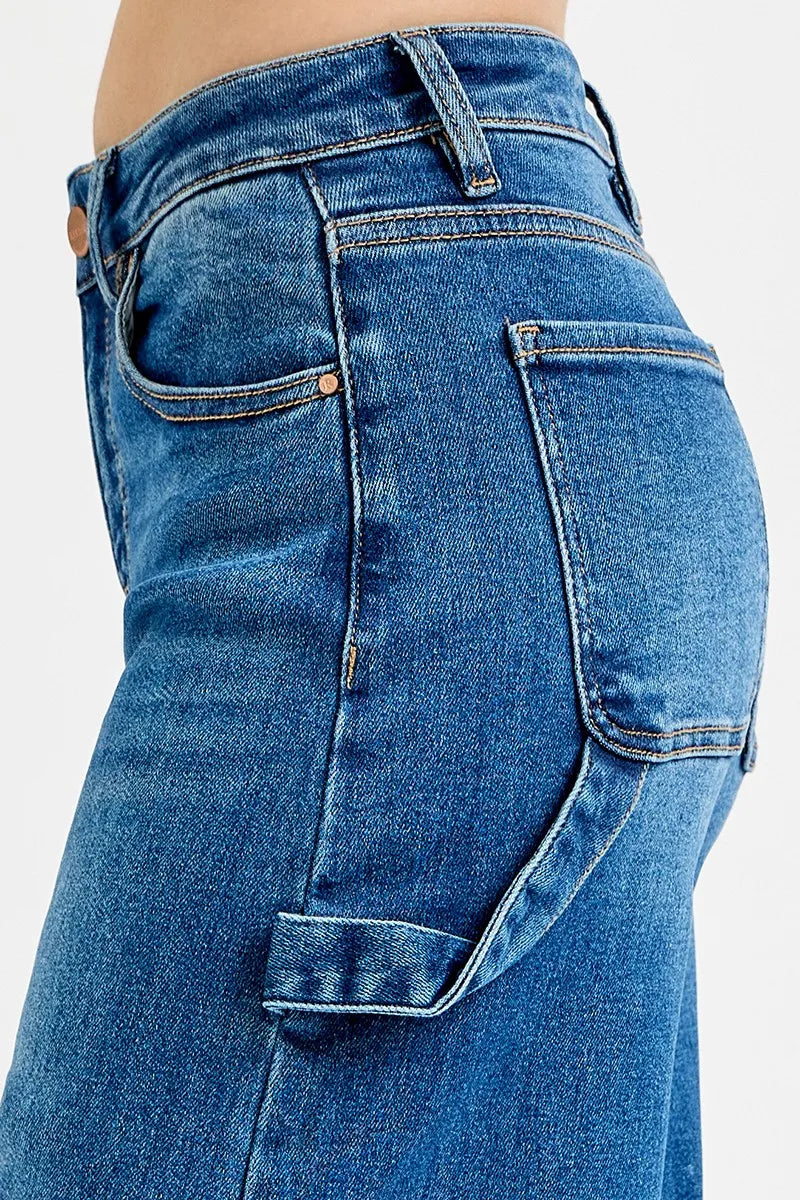 Close-up of dark denim jeans: belt loops, button, and front patch pocket
