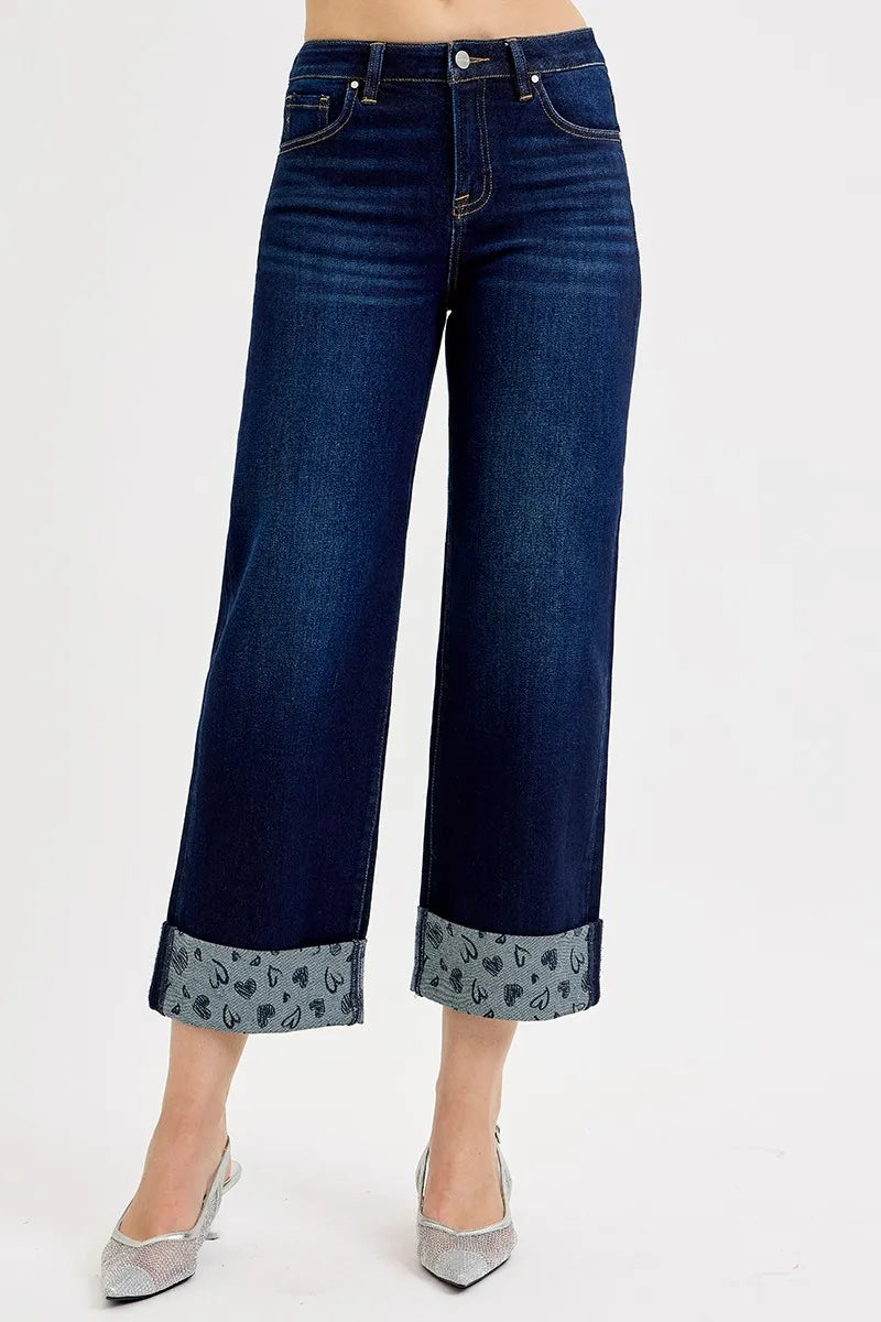 Front view of dark blue mid-rise wide-leg cropped jeans with patterned cuff