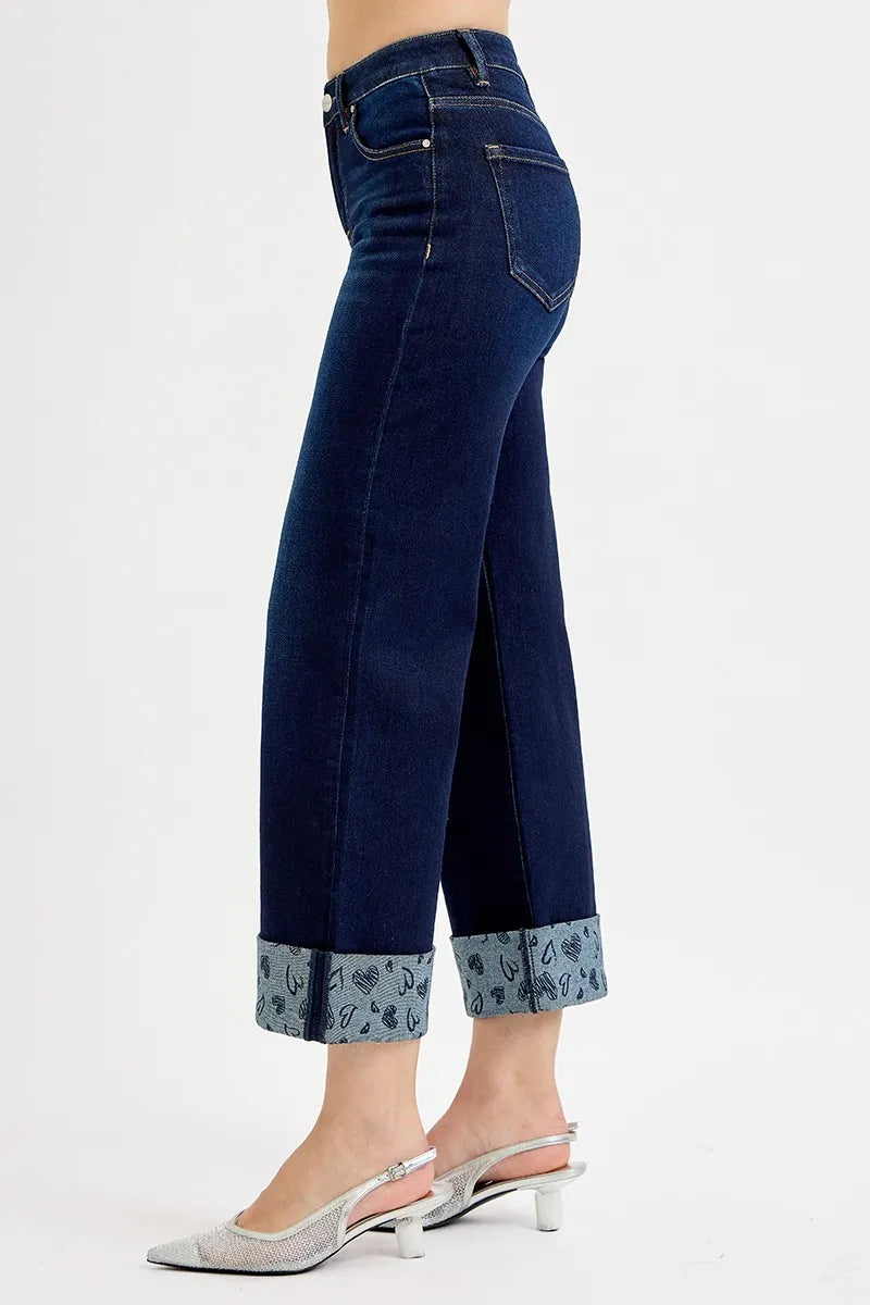 Side view of dark blue wide-leg cropped jeans with mid rise and patterned cuff