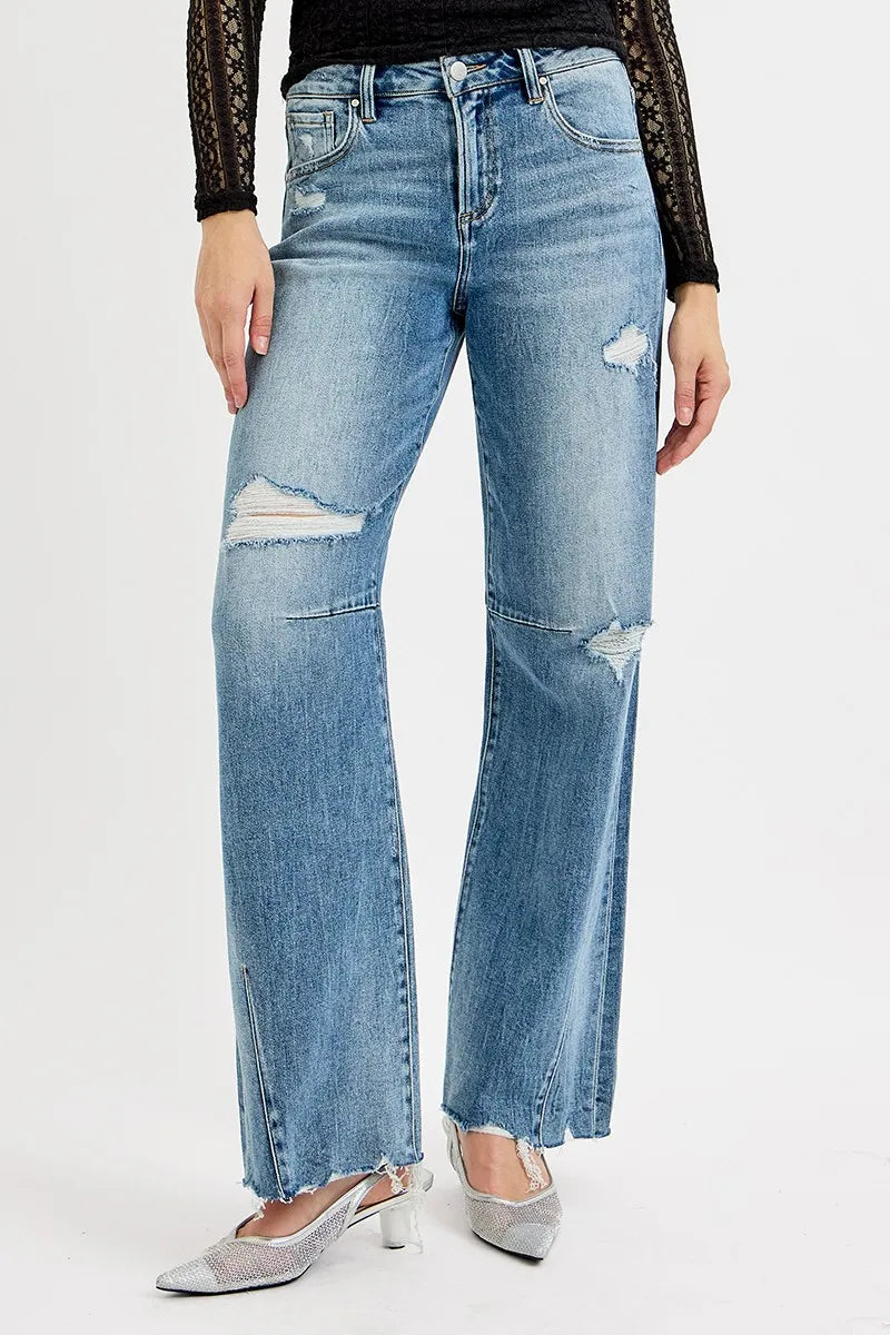 Medium wash wide-leg jeans with mid-rise fit, ripped patches, and frayed hems