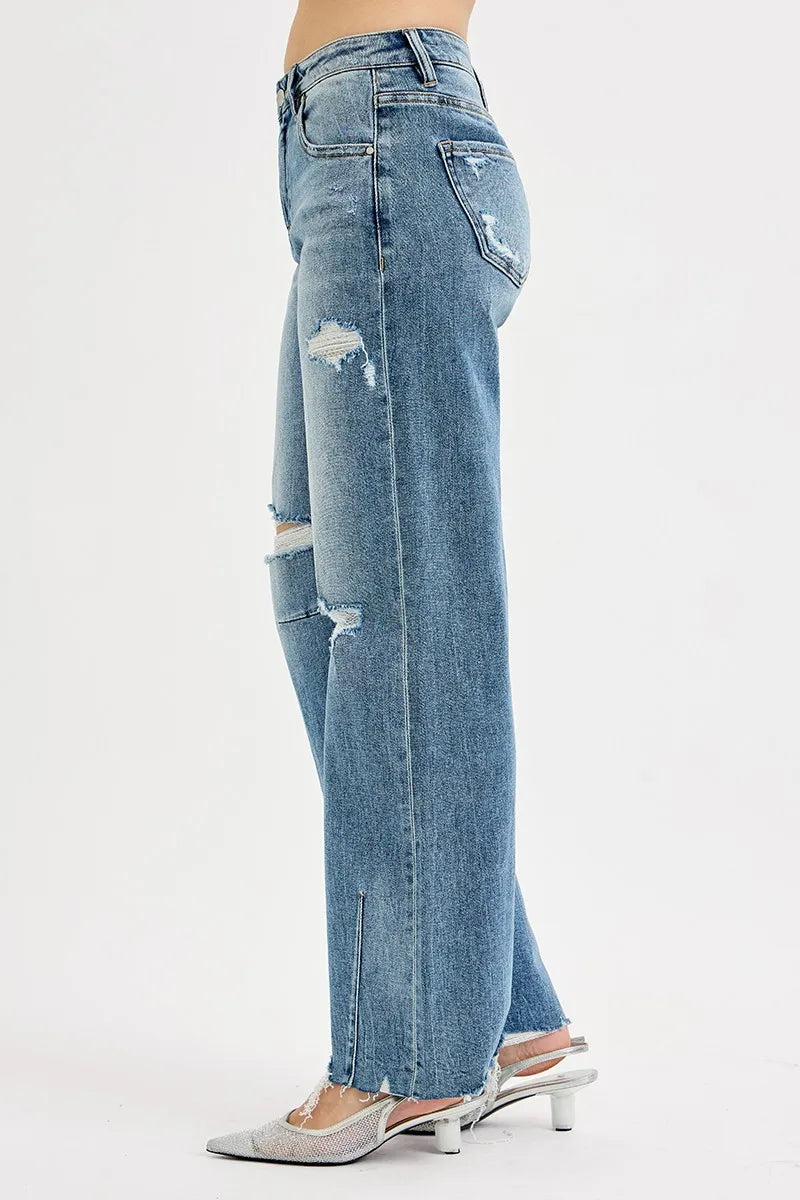 Side view medium-wash baggy jeans with knee rips, cuff fray, and back pocket