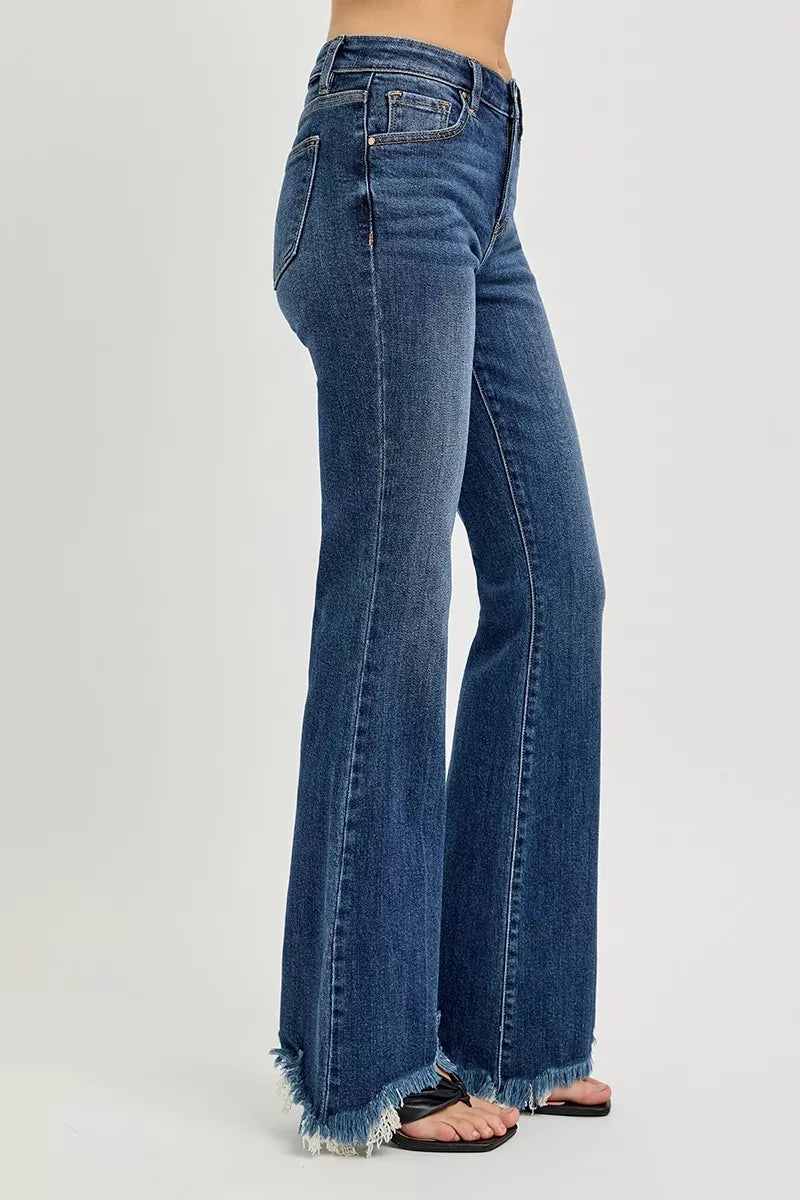 Dark wash mid-rise flare jeans in side view, finished with a frayed hem.