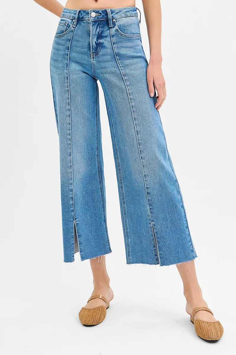 Medium wash wide-leg jeans showing front slit openings and mid-rise waistband