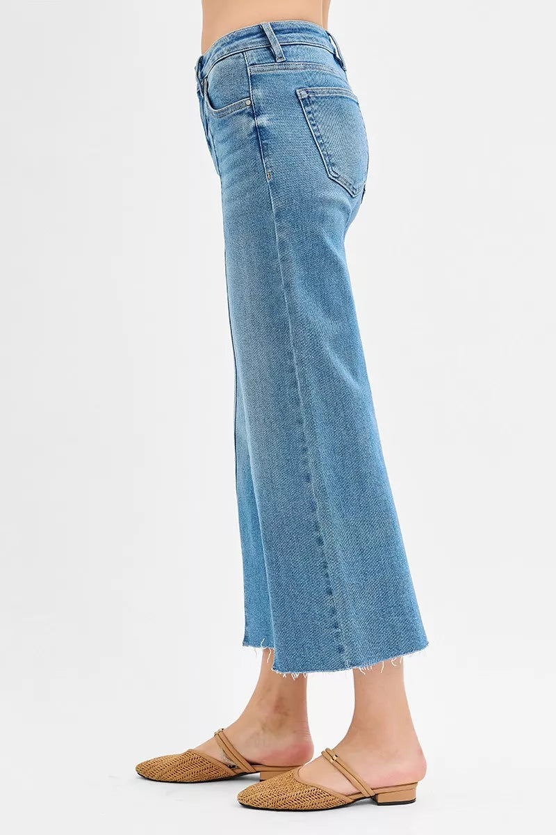Side view of medium wash mid-rise wide-leg jeans with front slit detail at hem