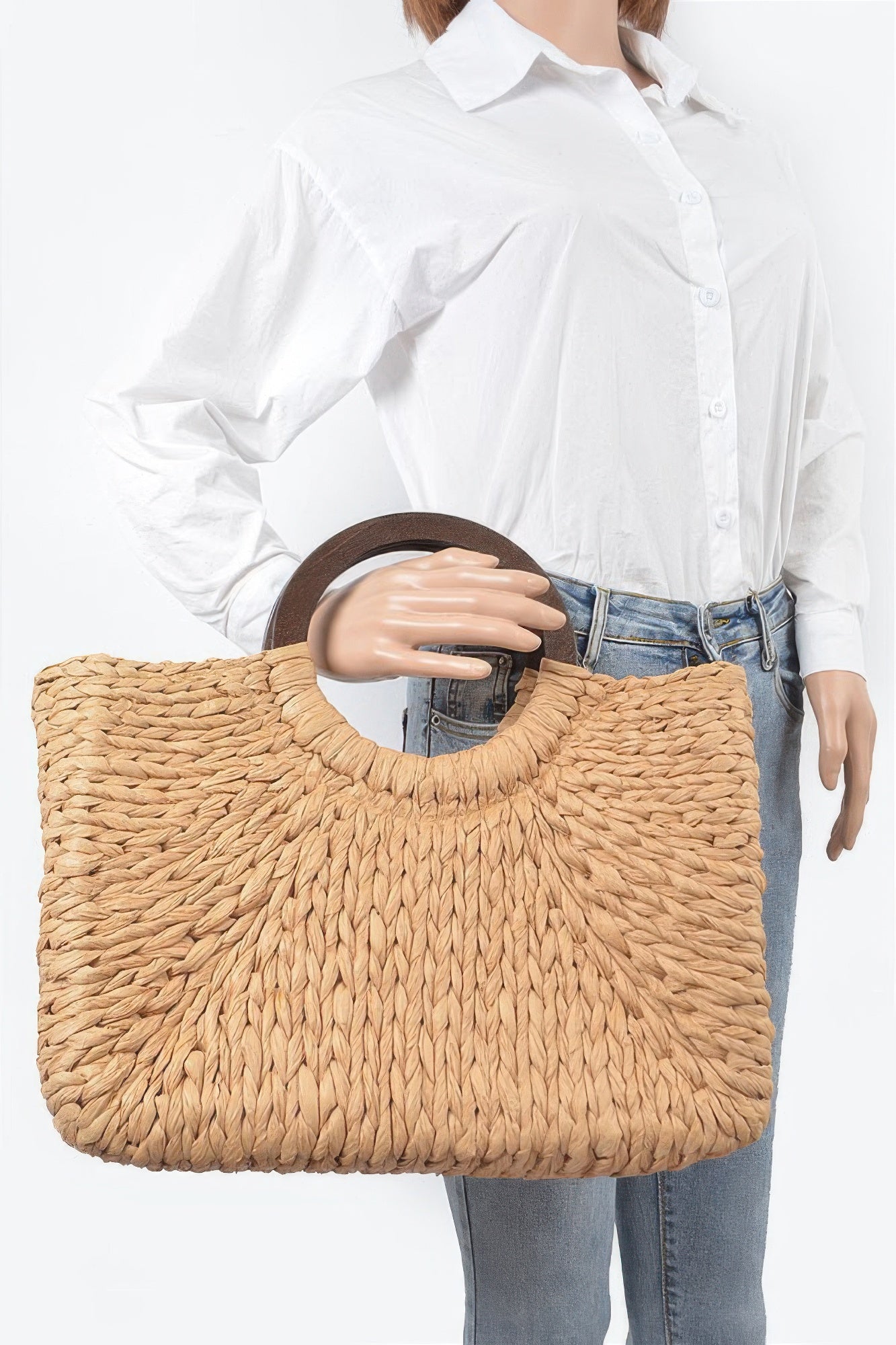 Woven straw tote with circular top handle, carried by model