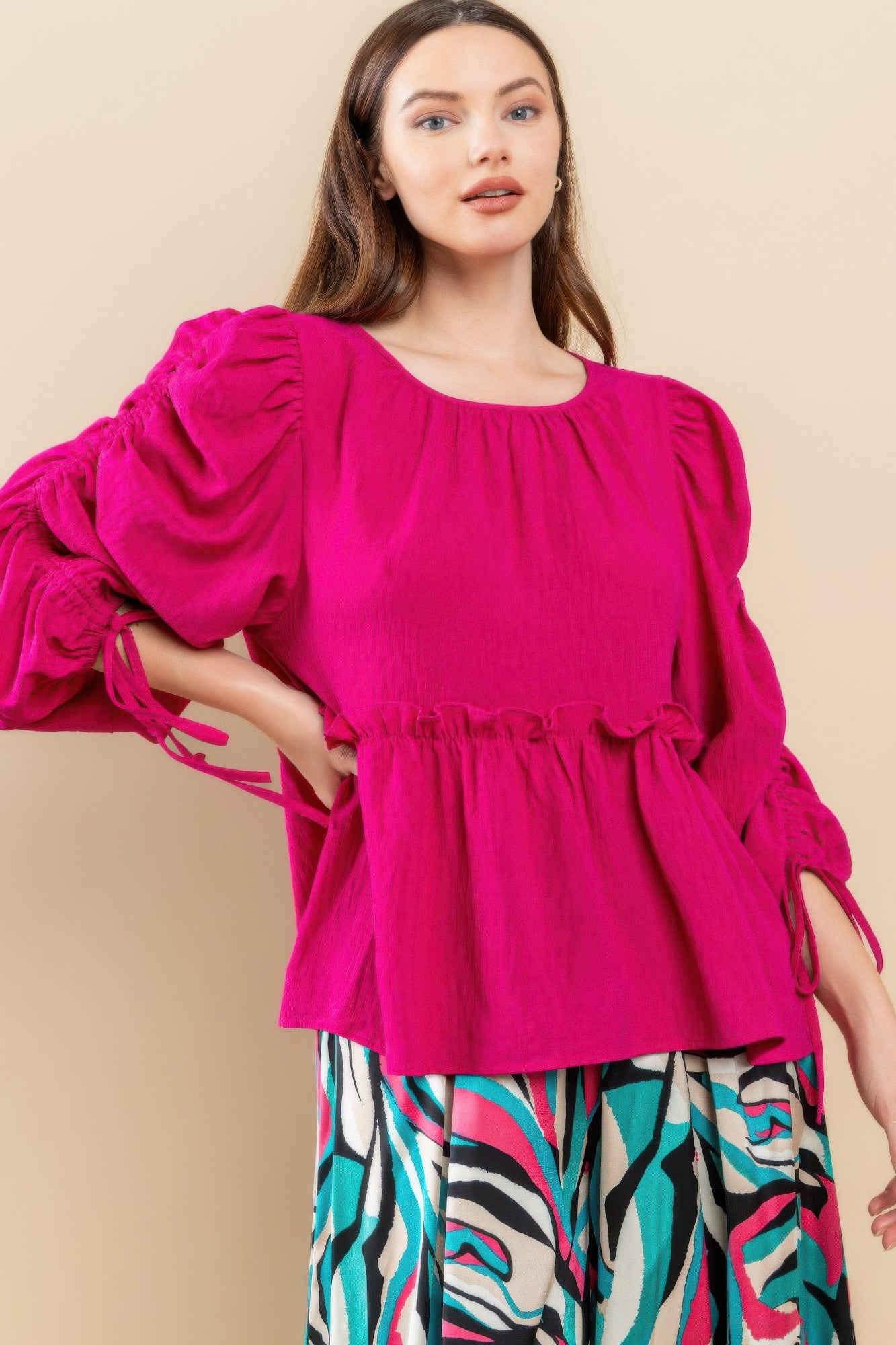 Magenta babydoll top with gathered waist and puff sleeves; side ties on sleeve cuffs