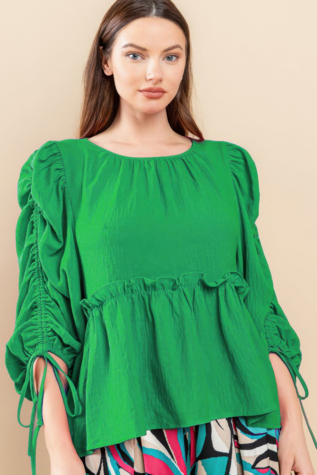 Kelly green babydoll top with round neckline, gathered waist, and puff sleeves