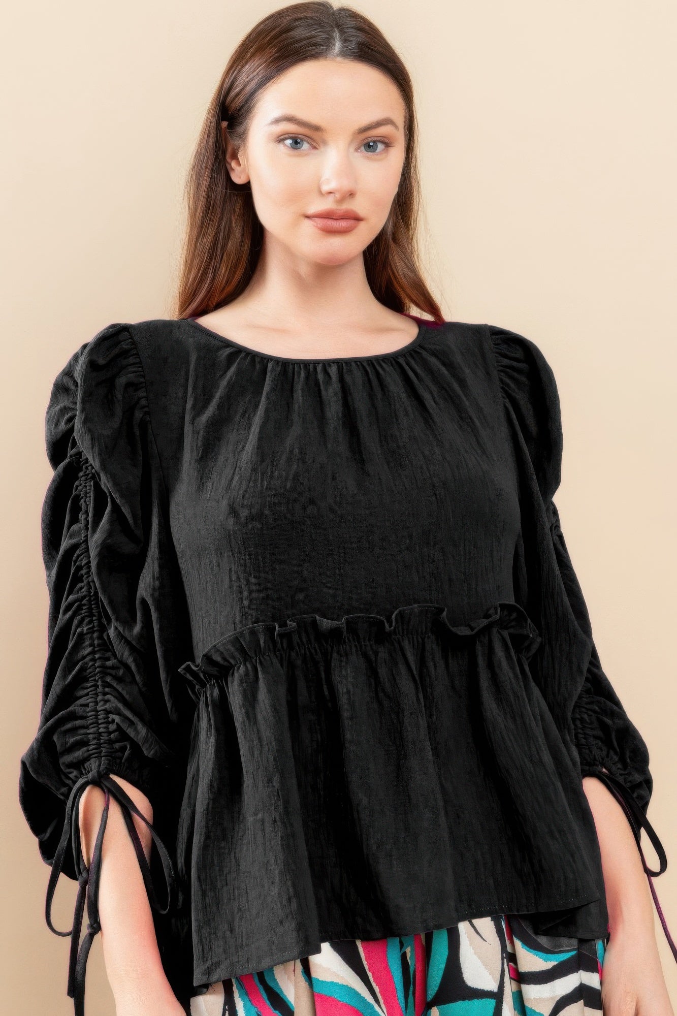 Black babydoll top with round neckline, puff sleeves, and gathered empire waist