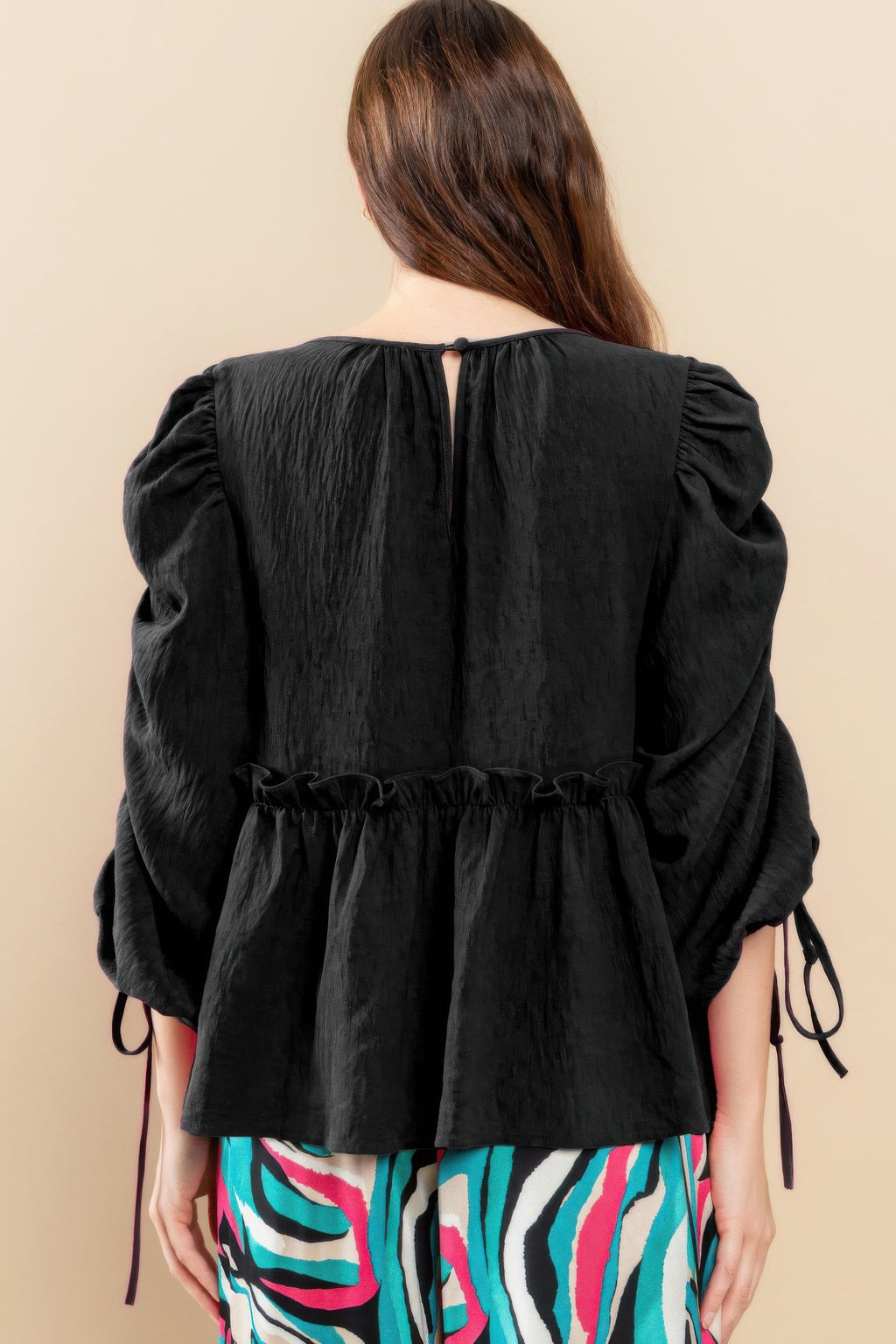 Black babydoll top back view with keyhole neckline tie and gathered puff sleeves