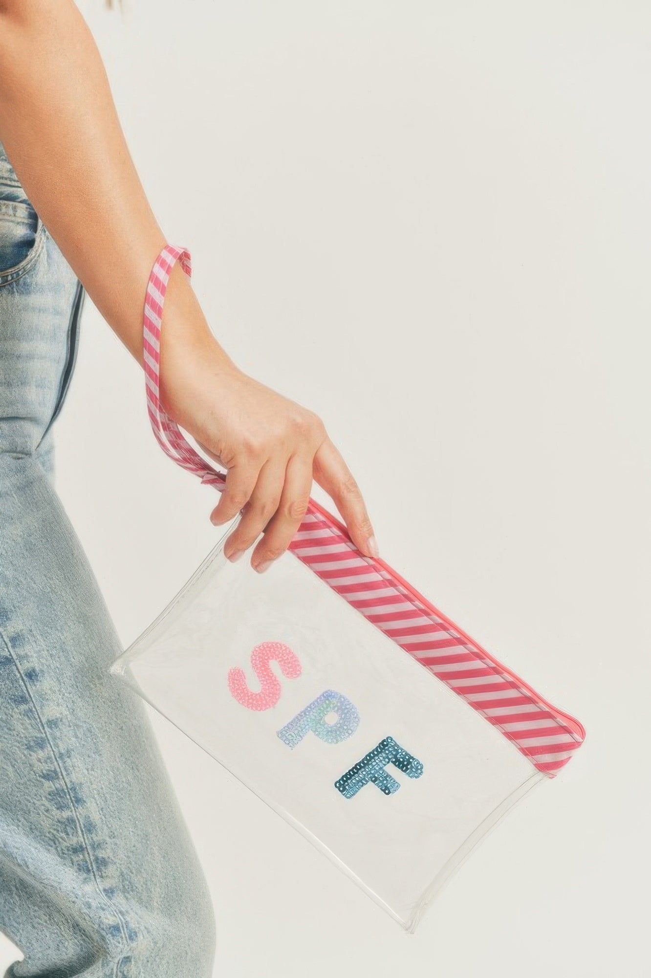 Clear sequin SPF pouch with pink-and-white striped wrist strap