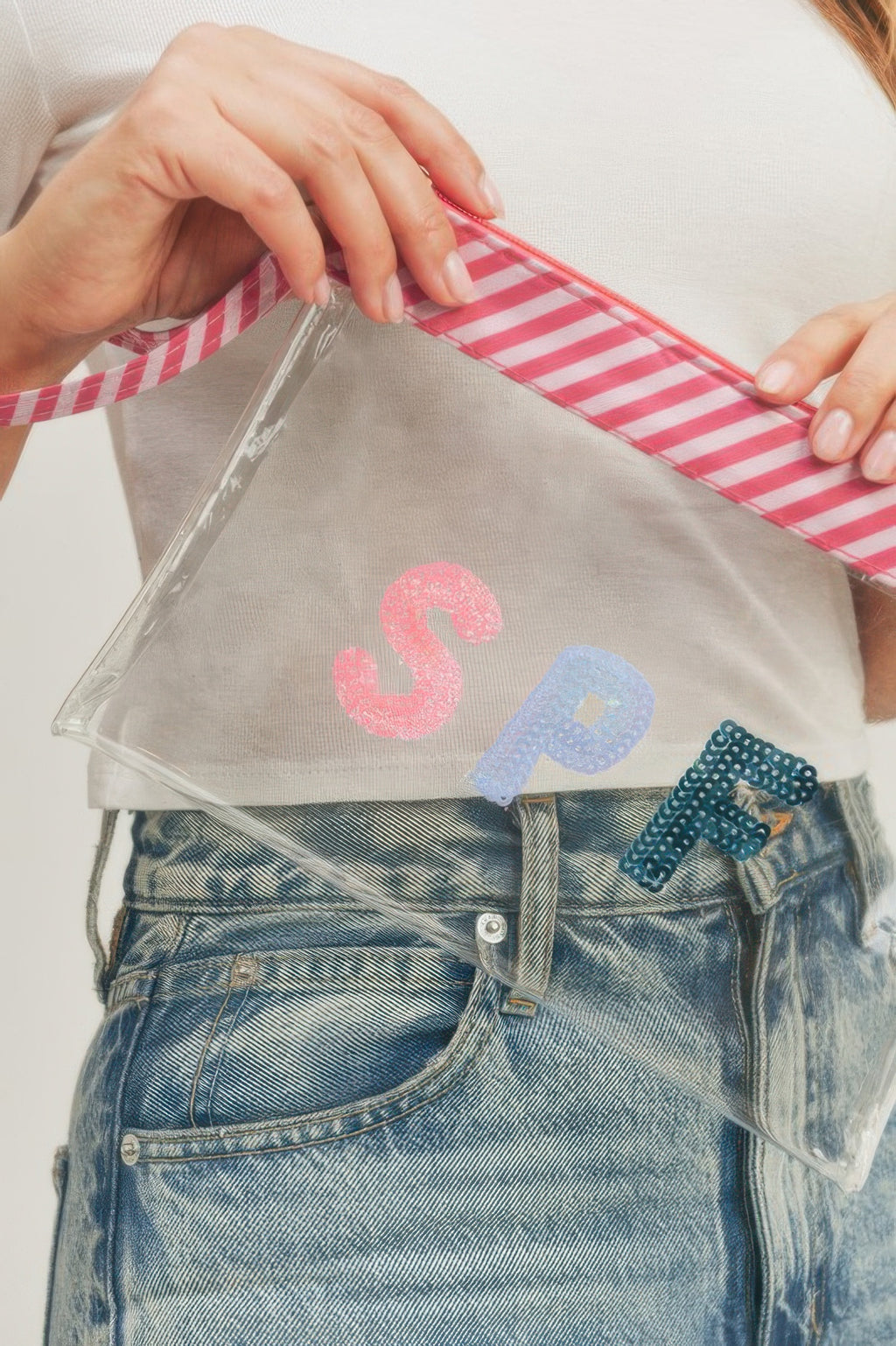 Clear SPF sequin pouch with pink striped strap and glittery S, P, F letters