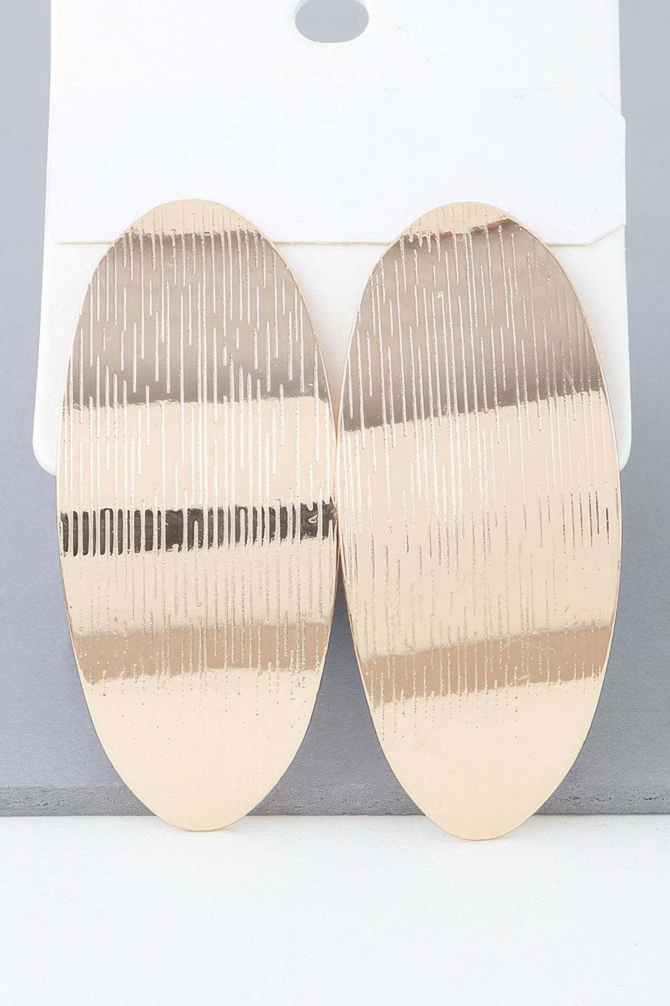 Shiny curved peel earrings in gold, ribbed curved oval shape