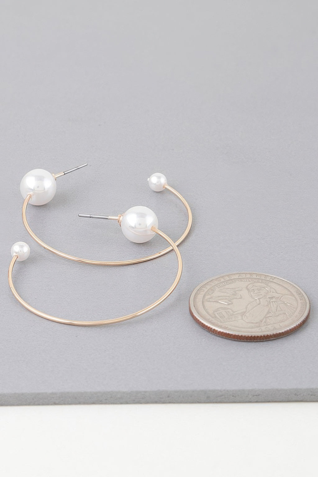 Delicate pearl hoop earrings, gold-toned hoops with round white pearl end caps