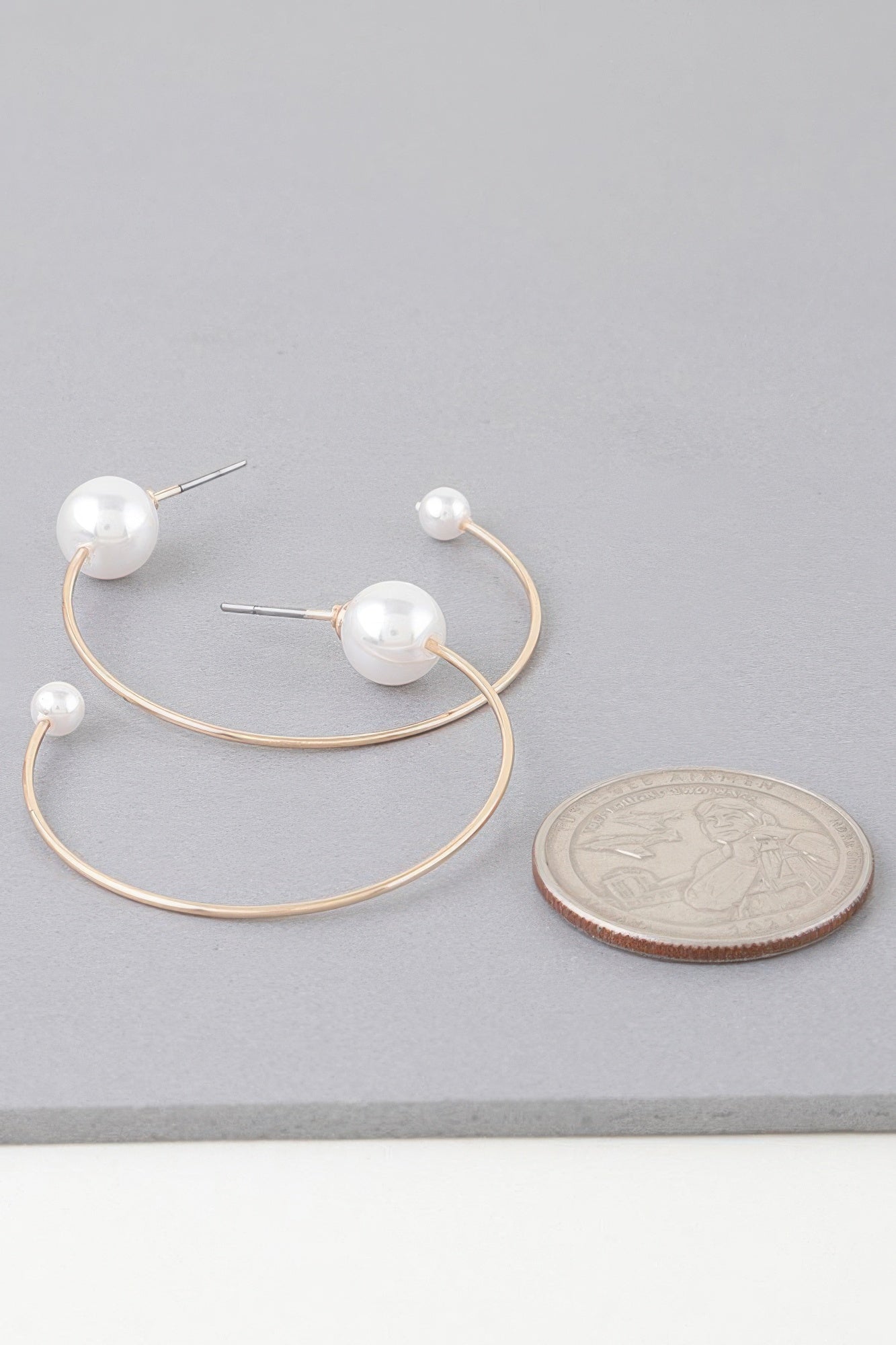 Delicate pearl hoop earrings, gold-toned hoops with round white pearl end caps